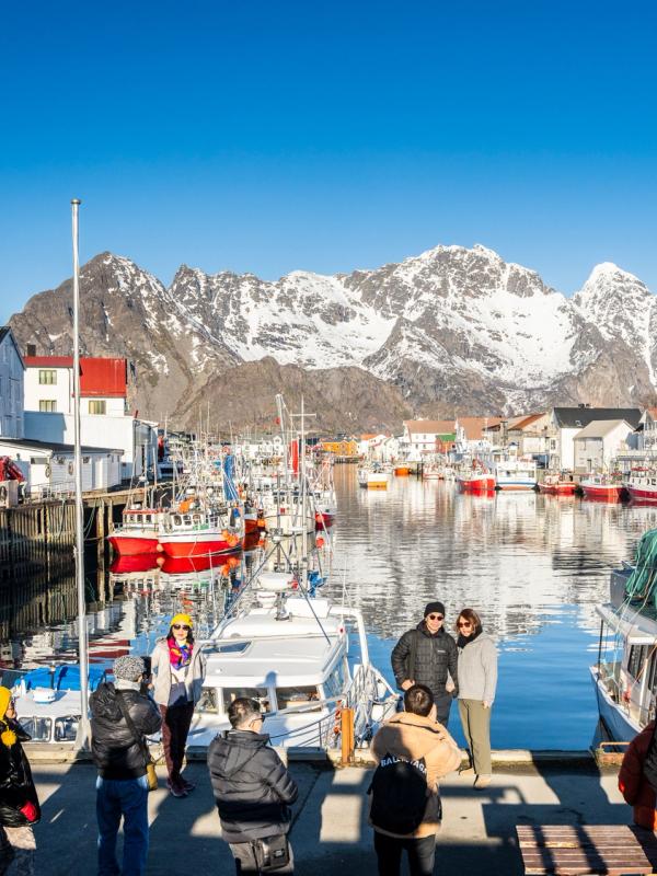 Turister som nyter utsikten fra brygga i Henningsvær