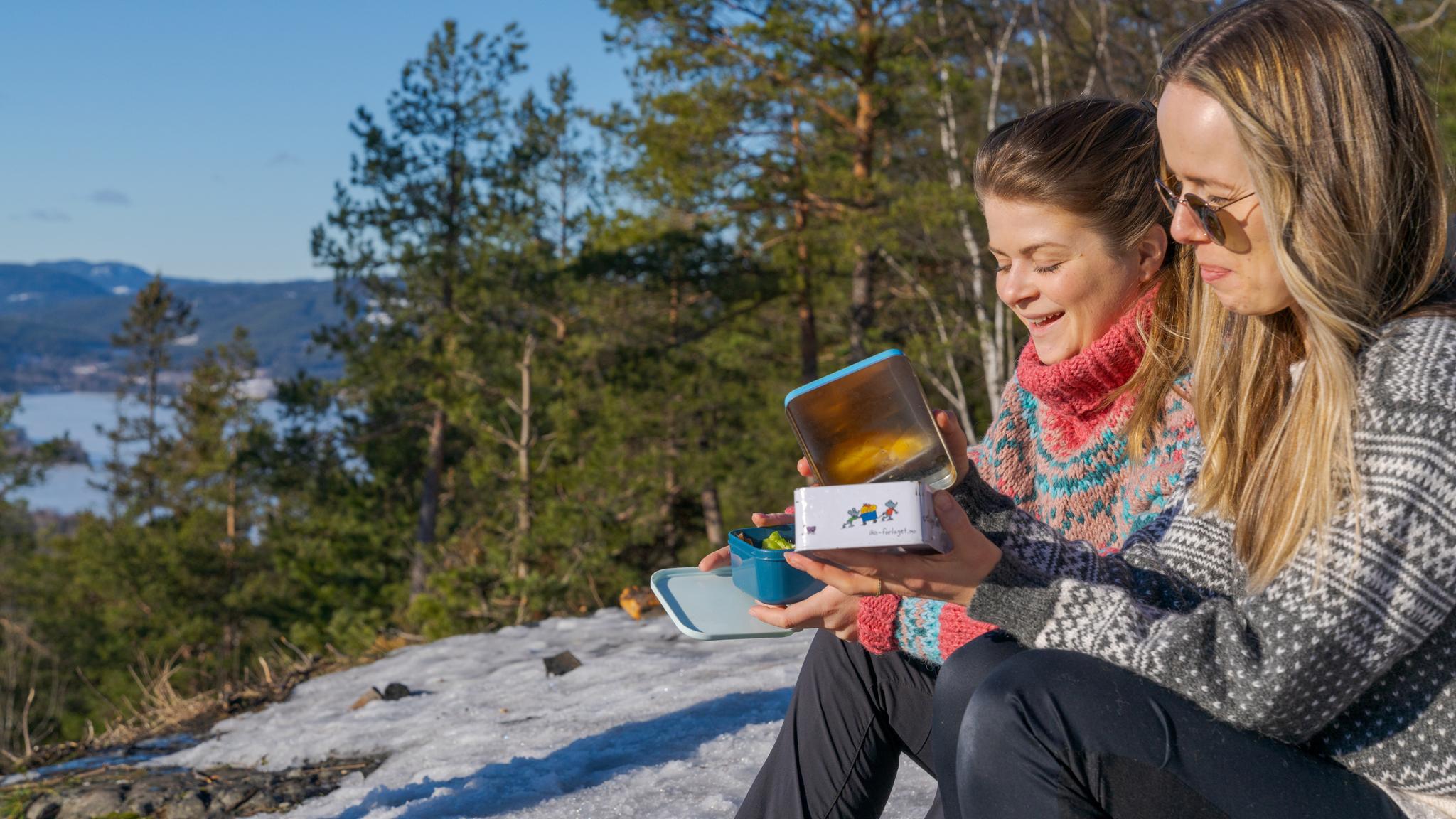 Two girls eating lunch with a view at Grefsenkollen viewpoint in Oslo