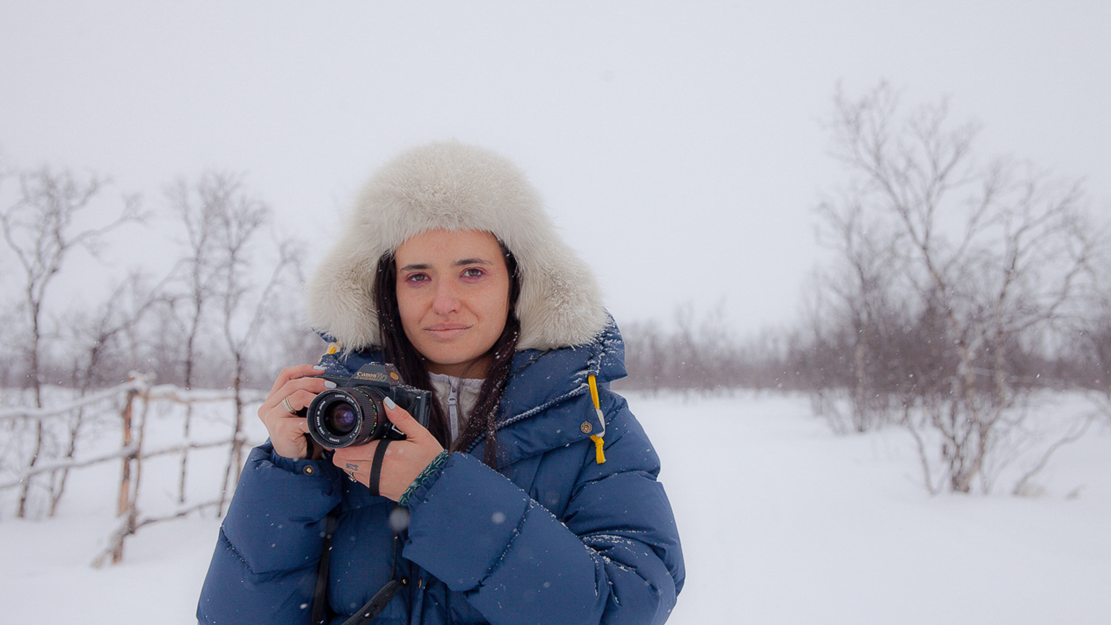 Italian woman with camera in the snow