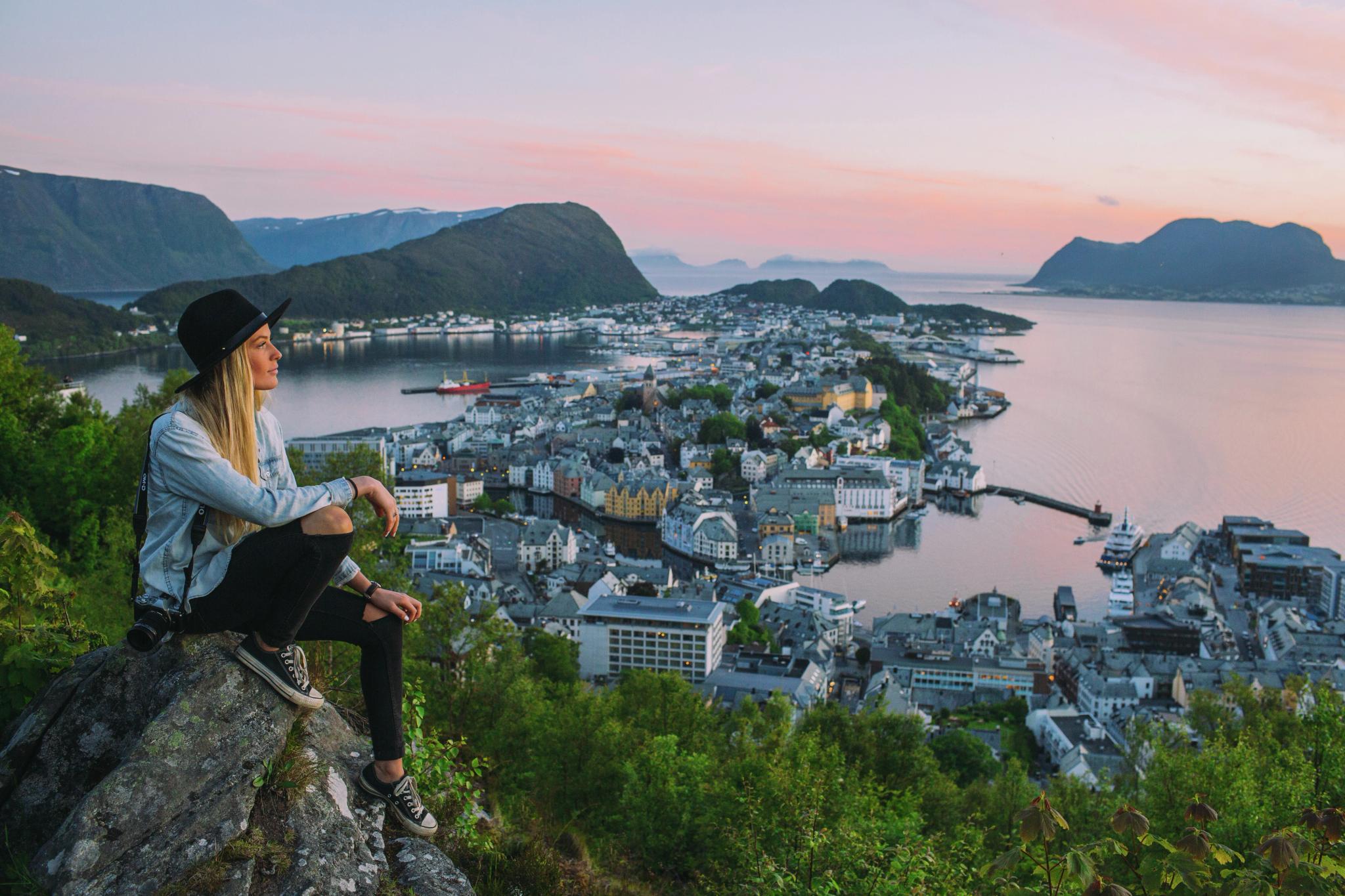 A woman on a city break in Norway is overlooking Ålesund from Aksla viewpoint