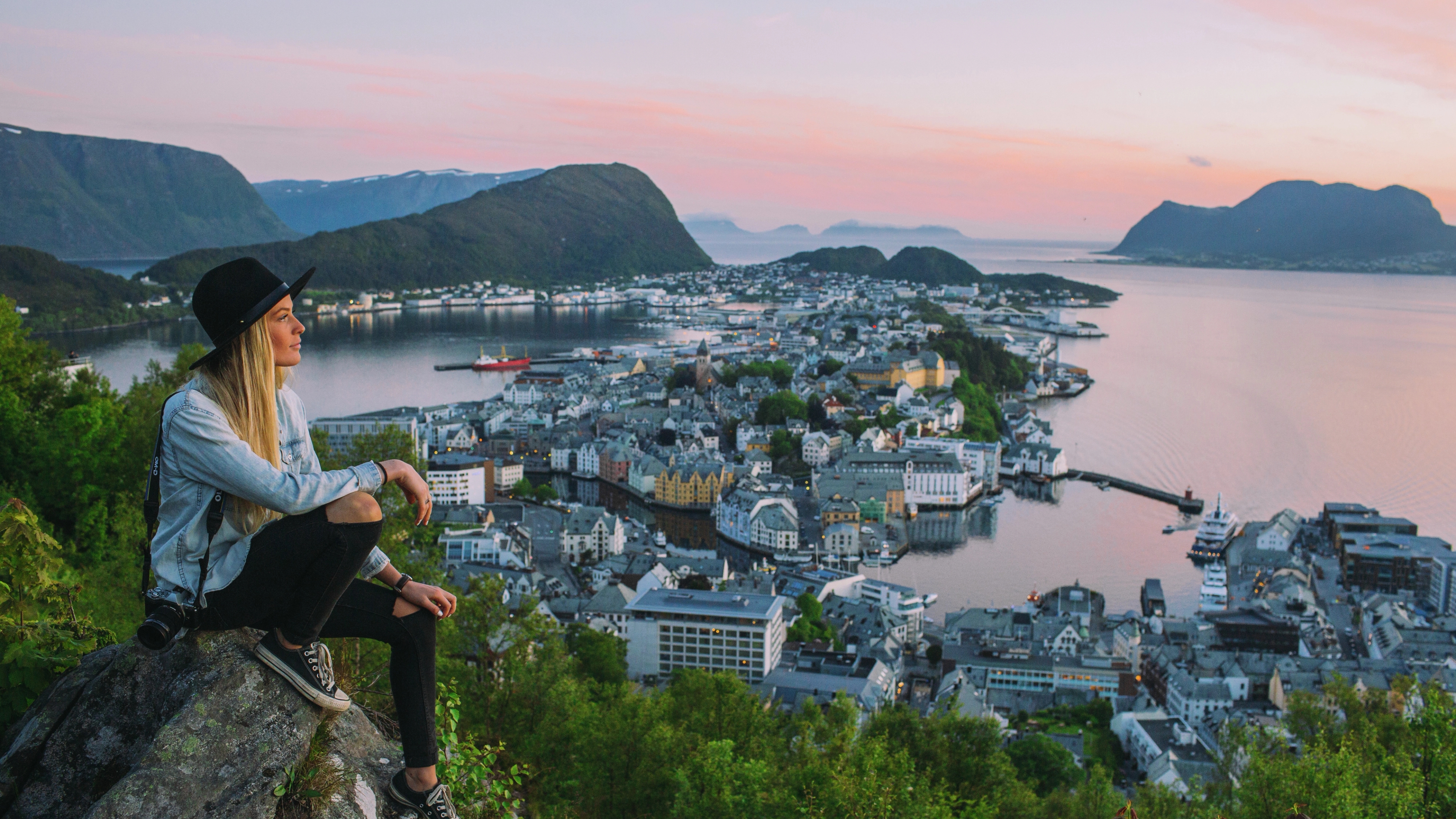 En dame sitter og skuer utover Ålesund fra Aksla utsiktspunkt