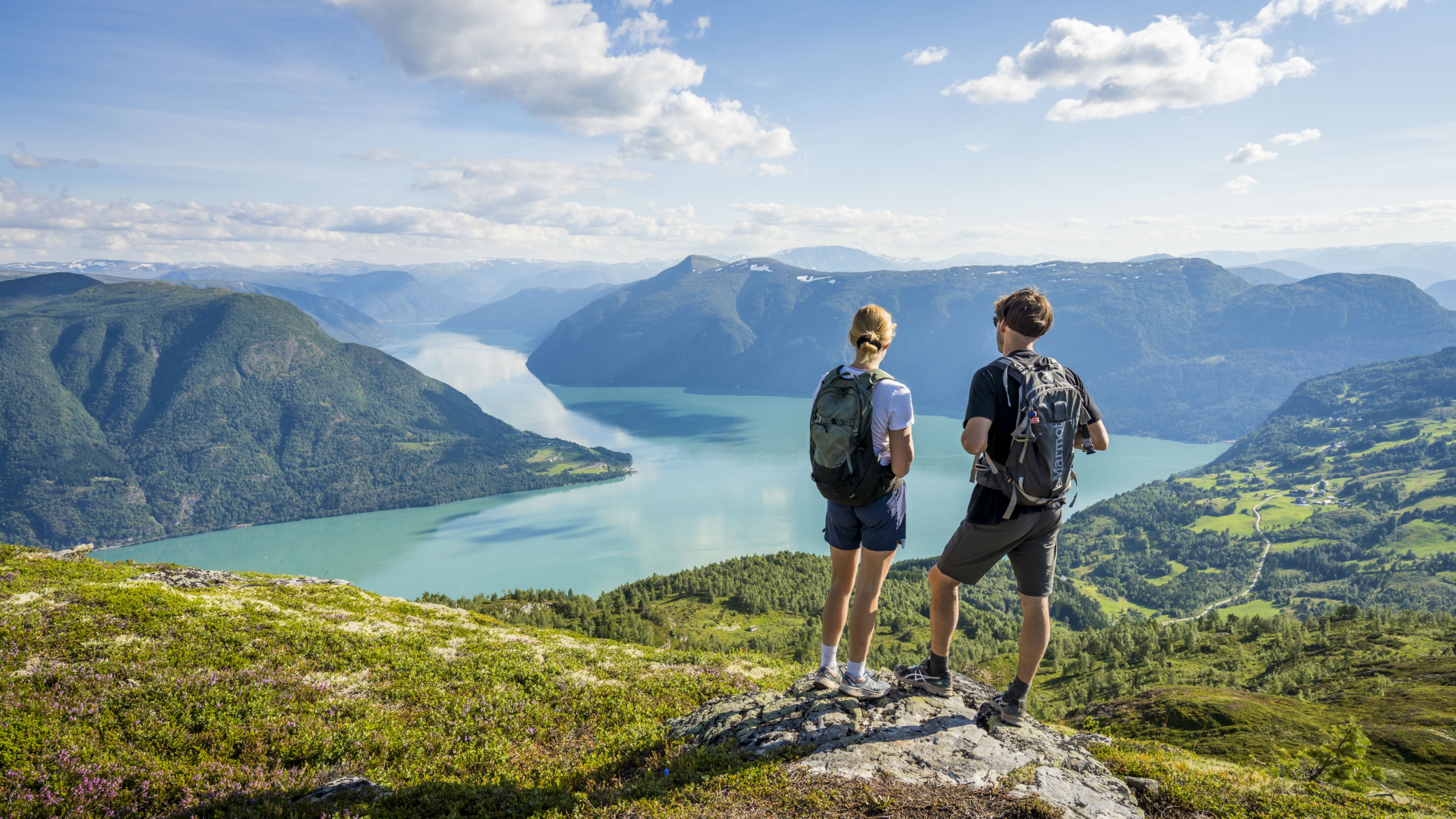 Two people admiring the view from the top of mount Molden in the Sognefjord area of Fjord Norway