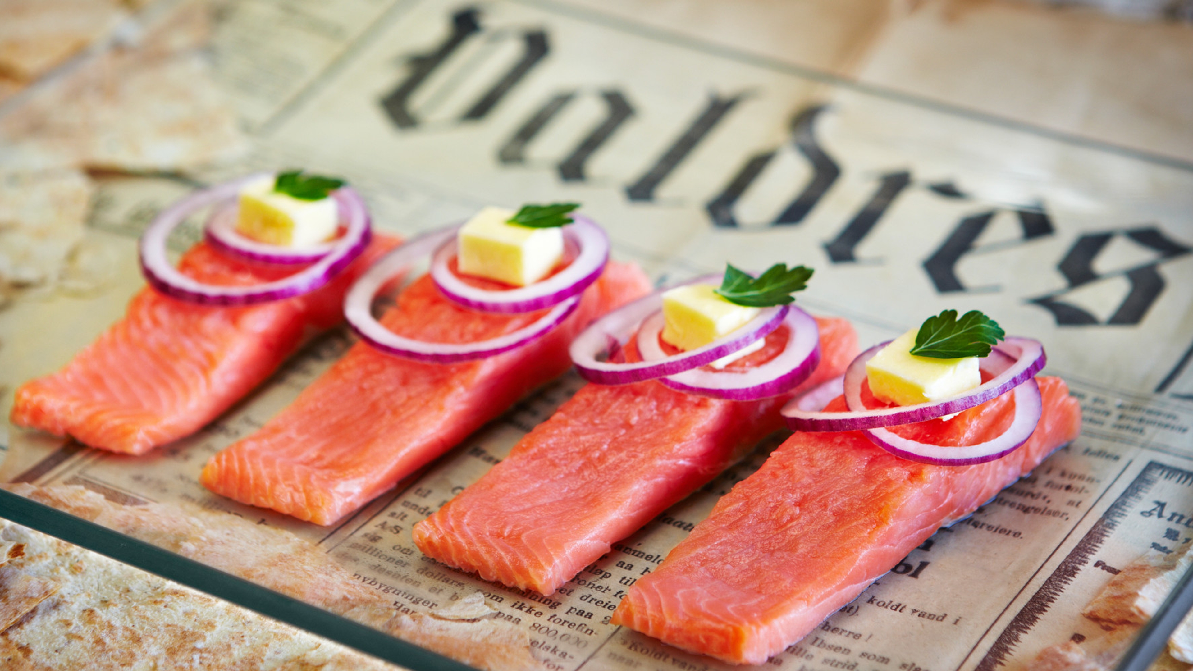 Rakfisk servert med rødløk og rømme