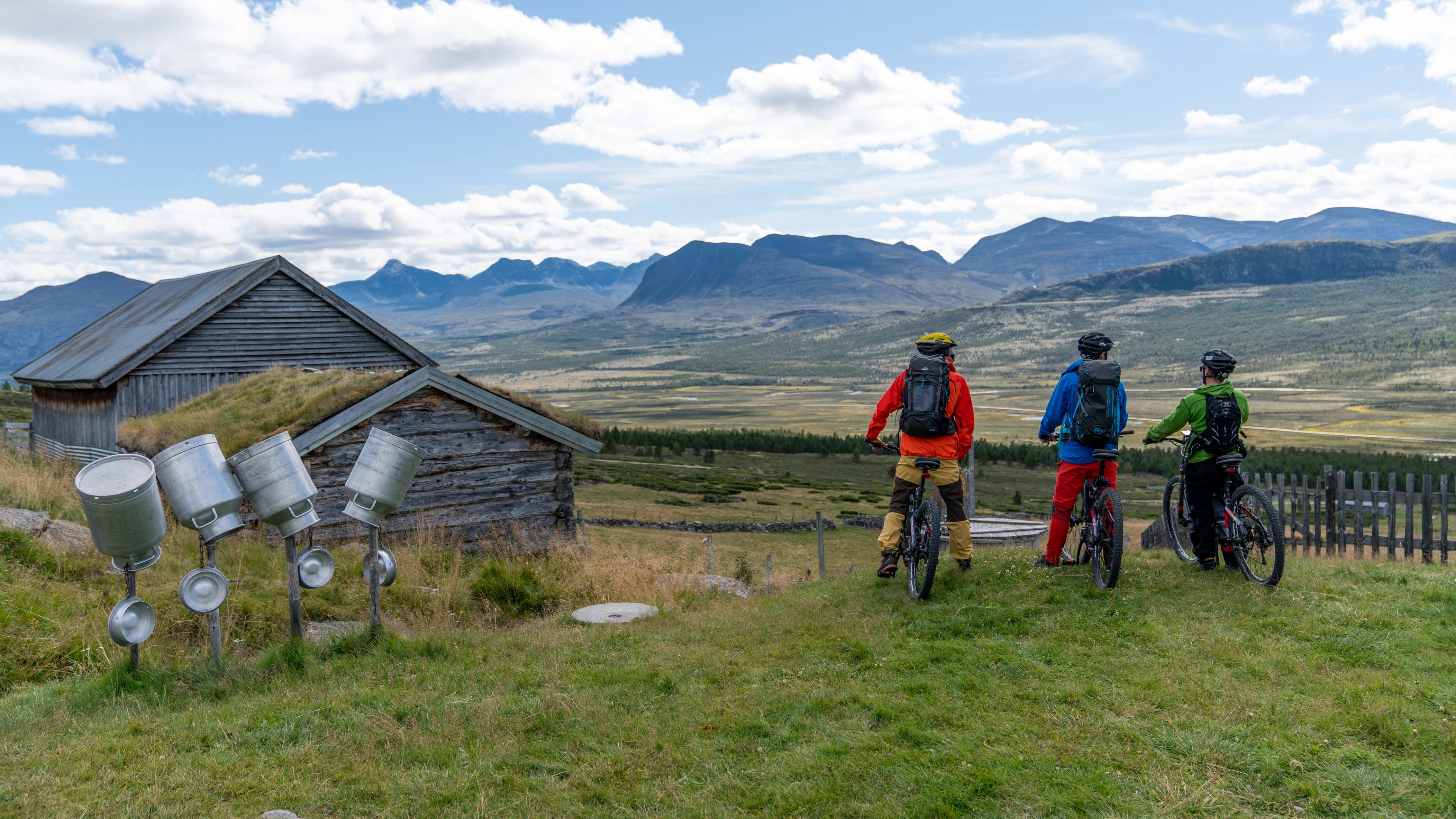 3 people are admiring the view on a bike ride through the Grimsdalen valley in Eastern Norway