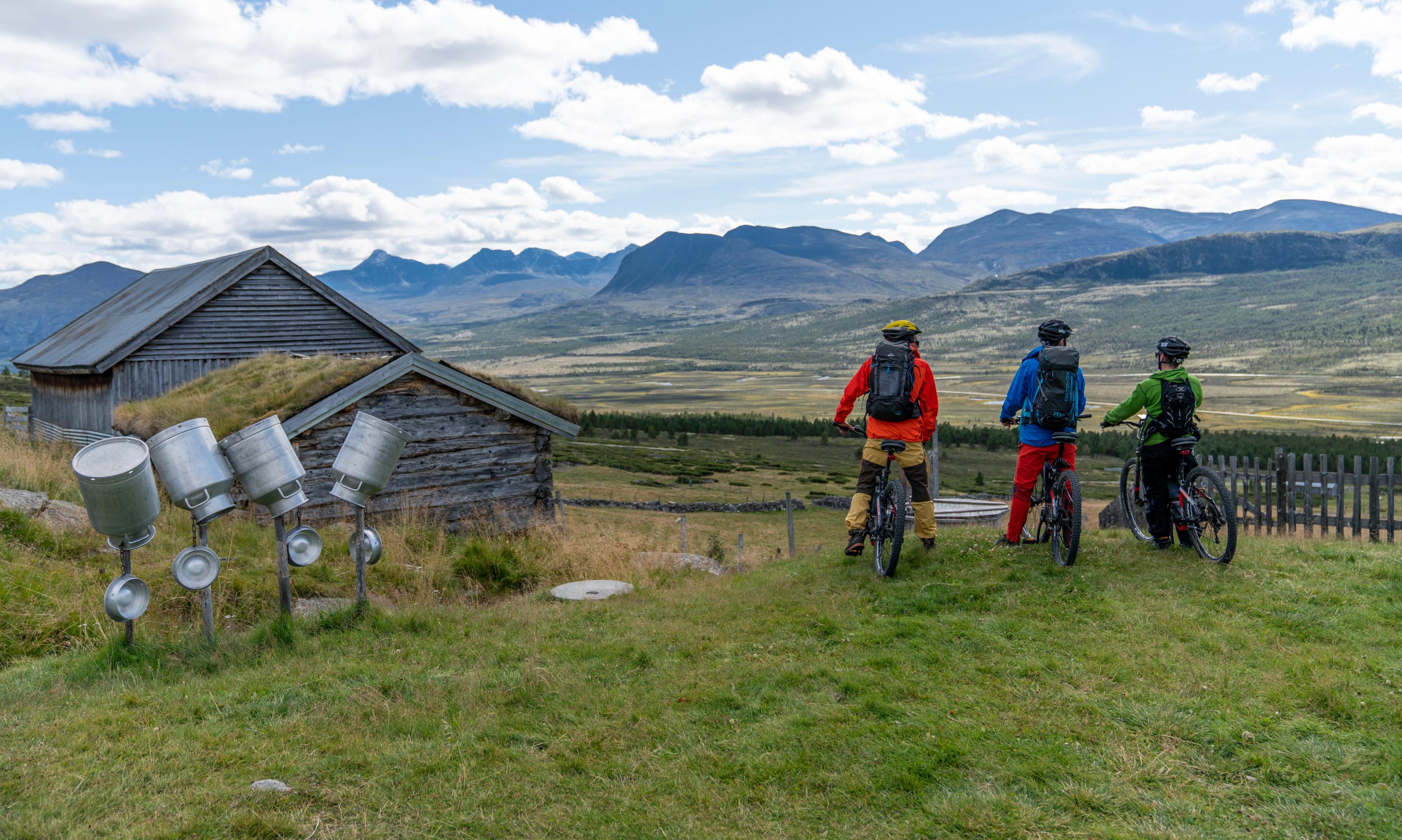 3 people are admiring the view on a bike ride through the Grimsdalen valley in Eastern Norway