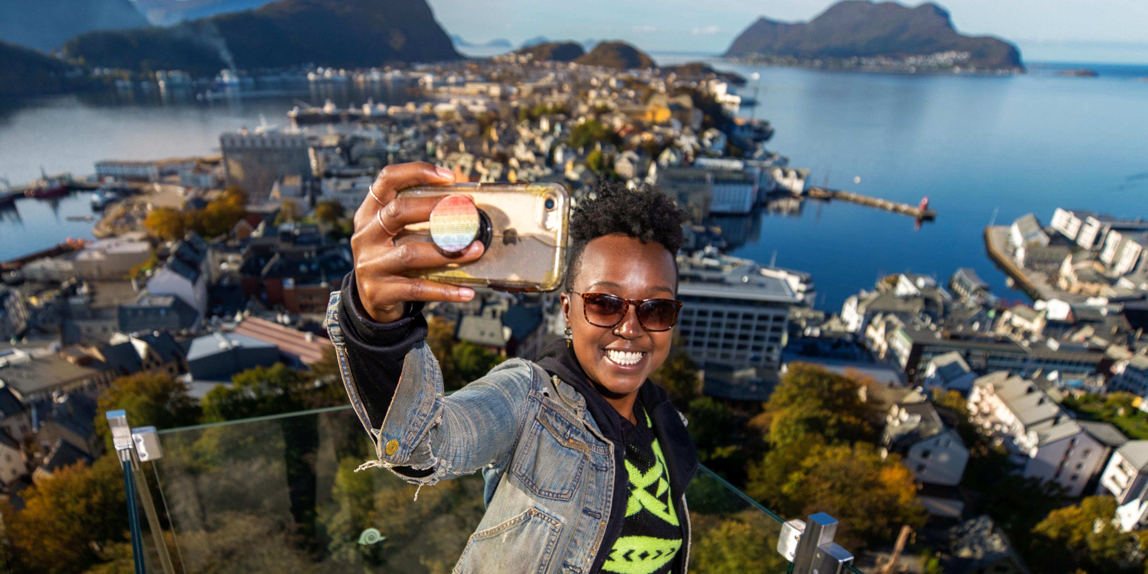 A woman taking a selfie at Aksla in Ålesund, Norway.