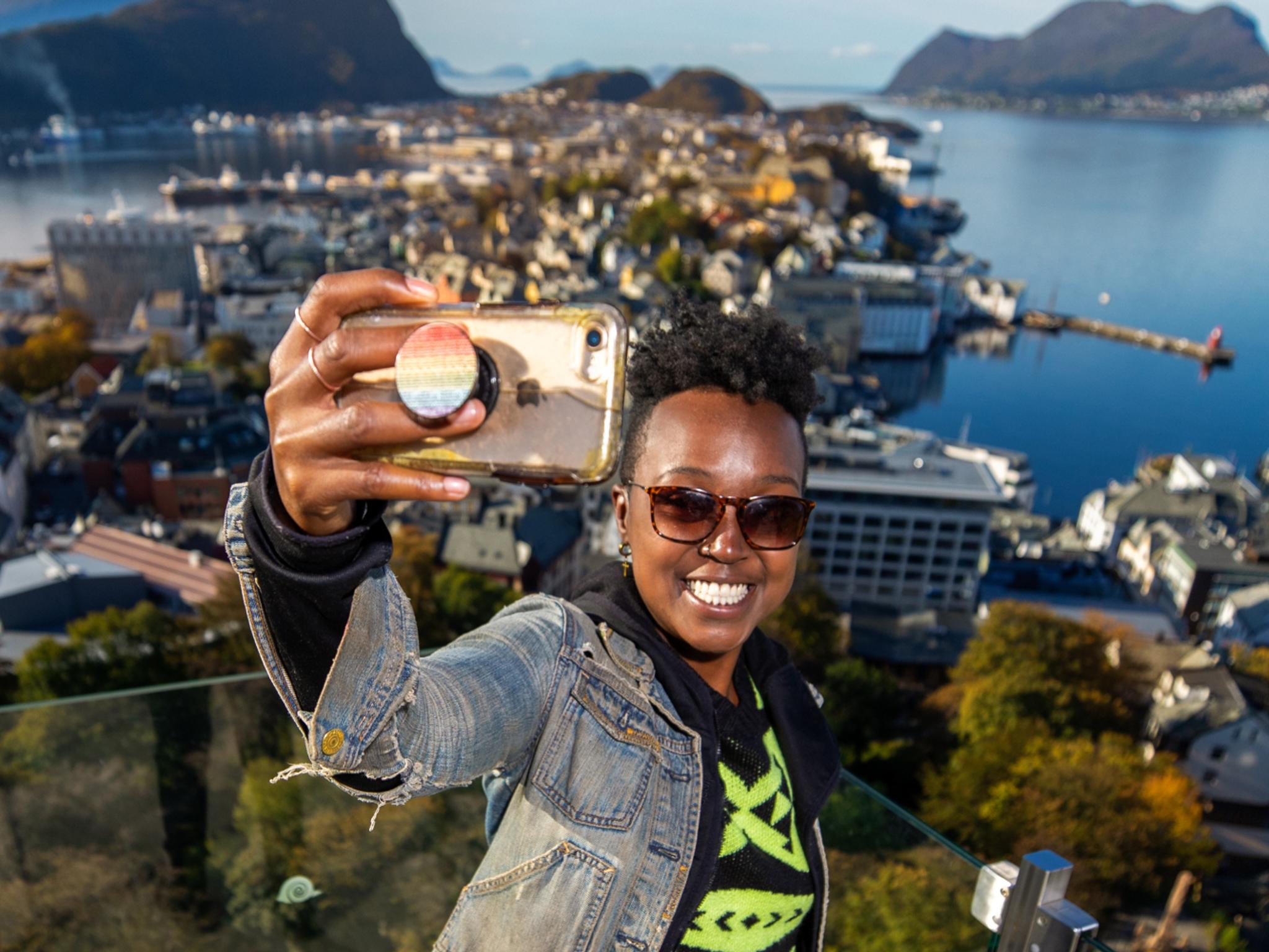 A woman taking a selfie at Aksla in Ålesund, Norway.