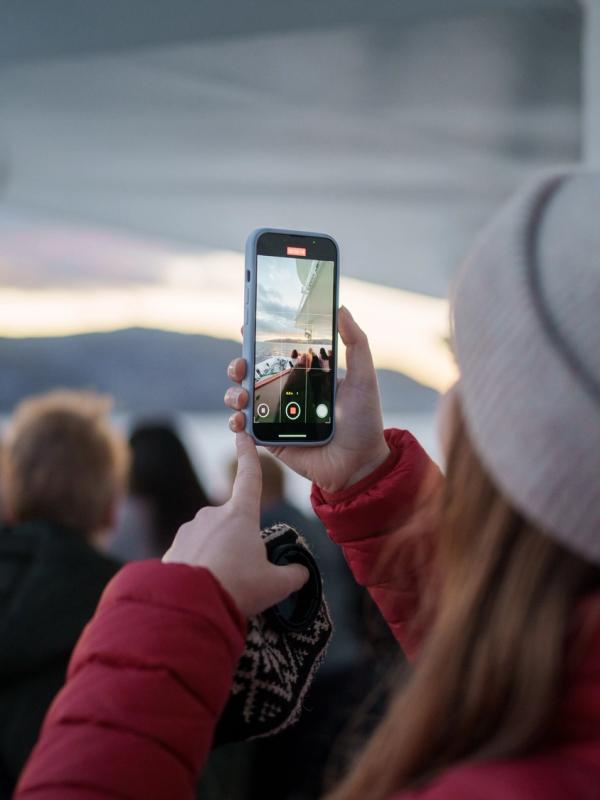 Woman filming a video on deck at Hurtigruten