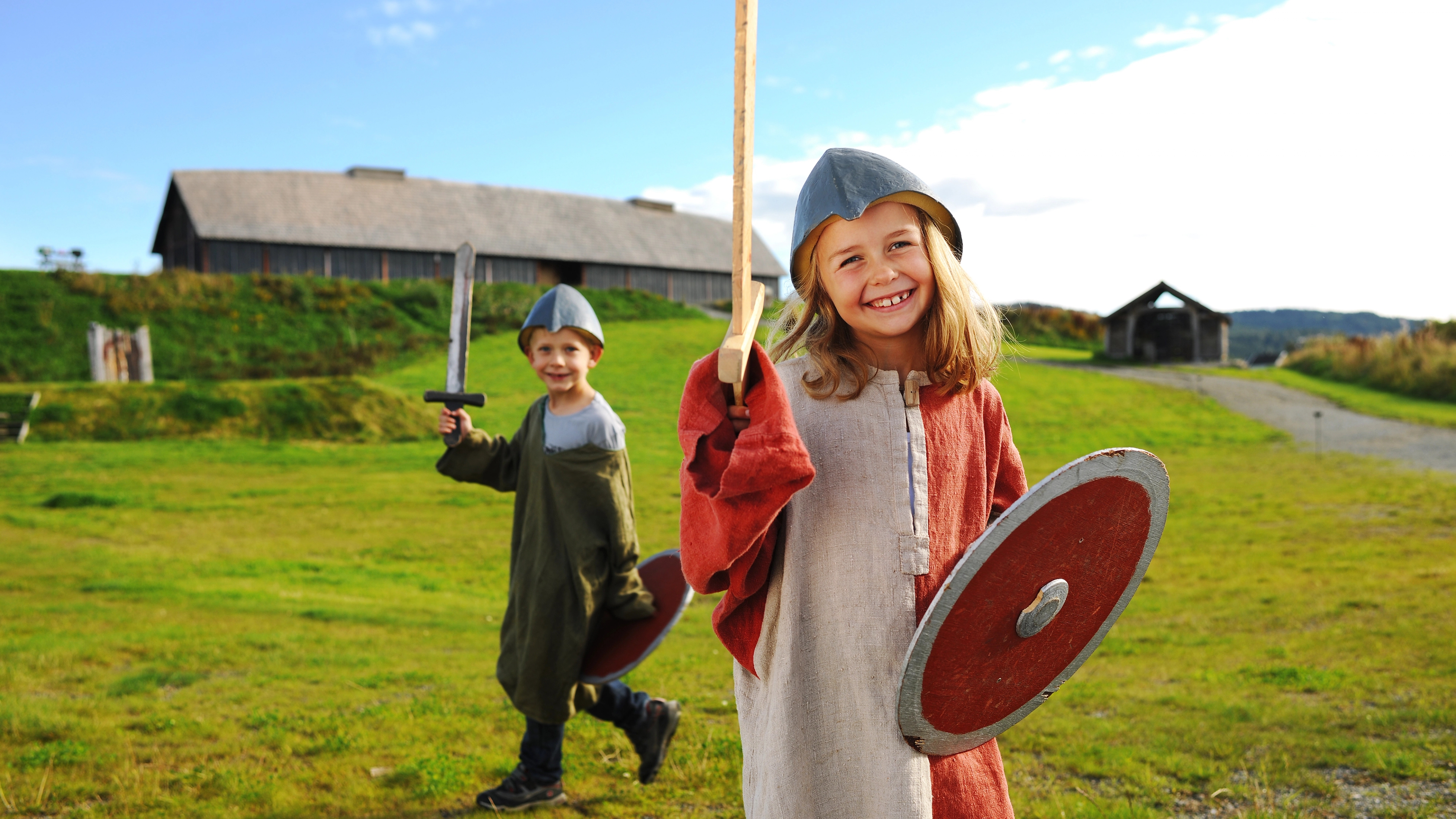 Children dressed as Vikings in front of a longhouse at Stiklestad in Trøndelag, Norway