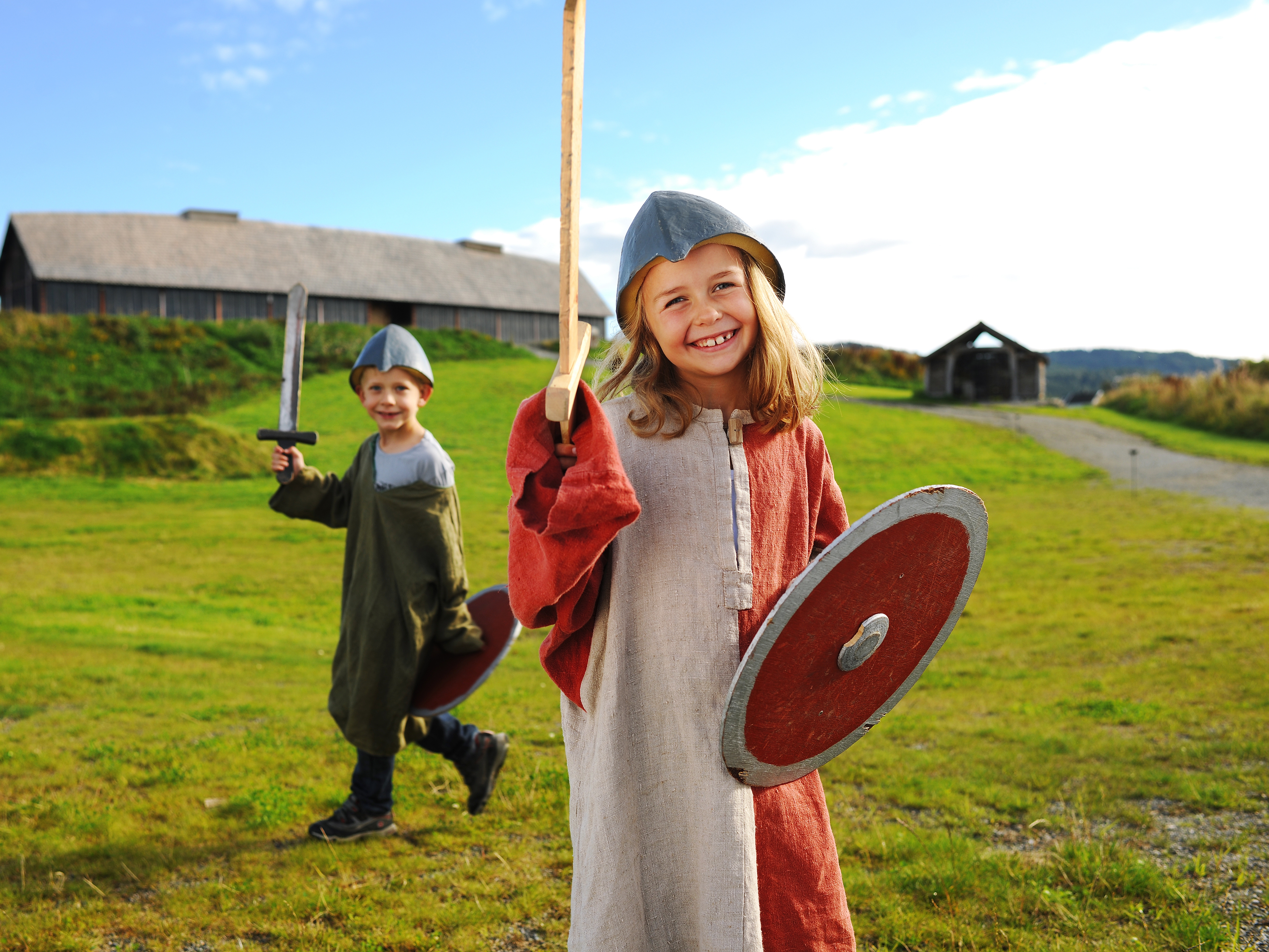 Children dressed as Vikings in front of a longhouse at Stiklestad in Trøndelag, Norway
