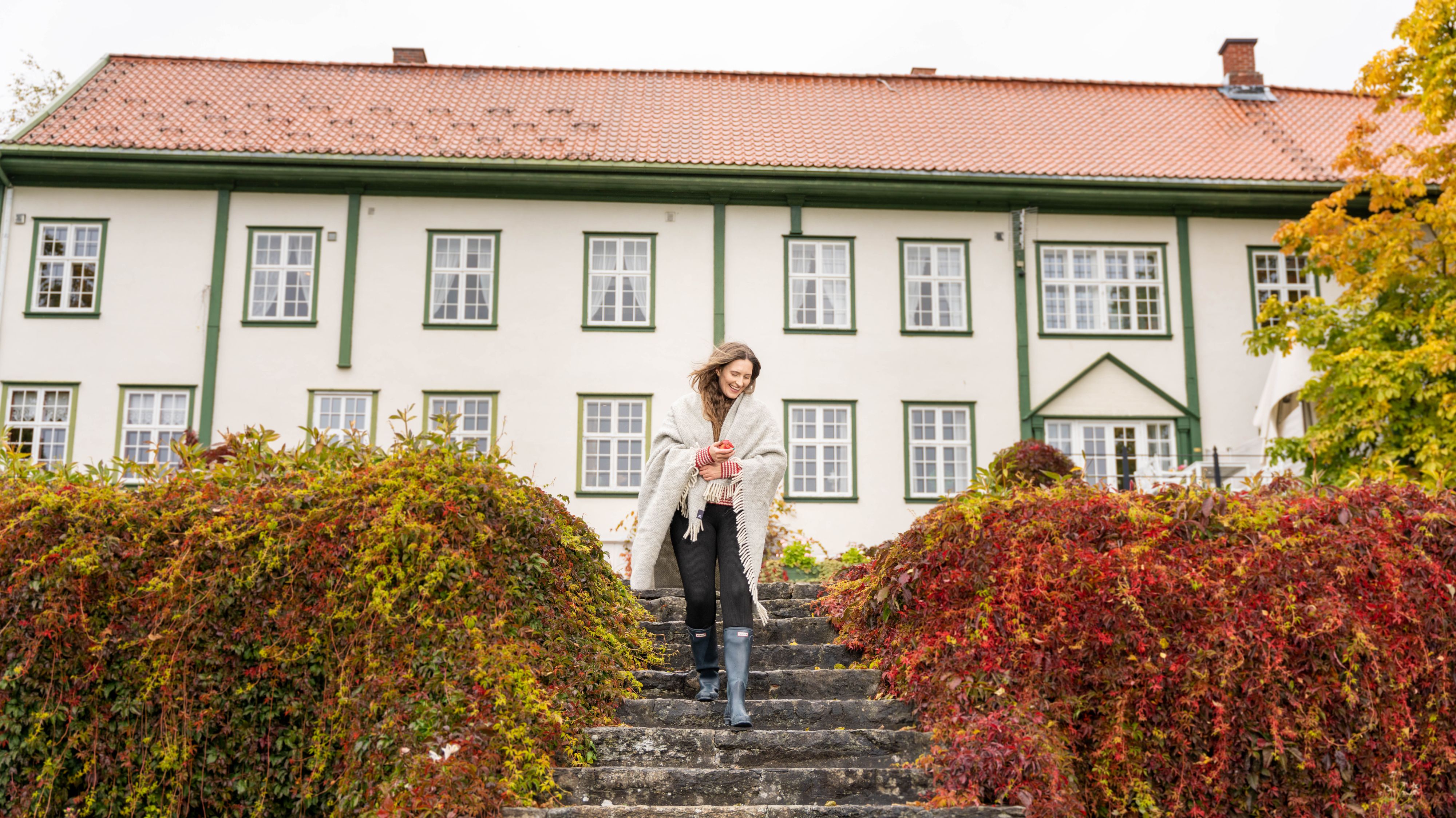 A woman goes for a stroll in the garden at Hoel Farm, Eastern Norway.