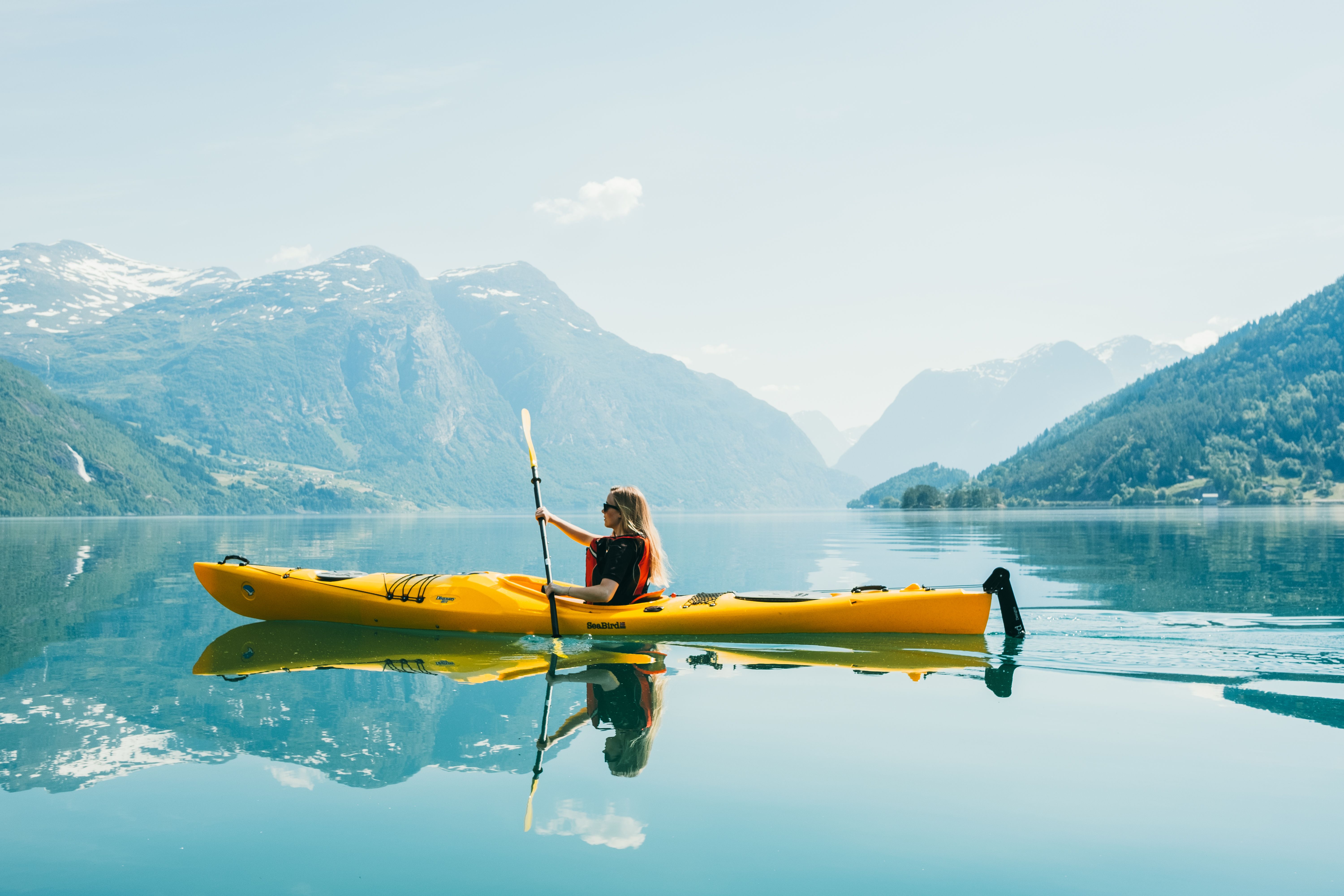 Woman kayaking on Lovatnet, Fjord Norway
