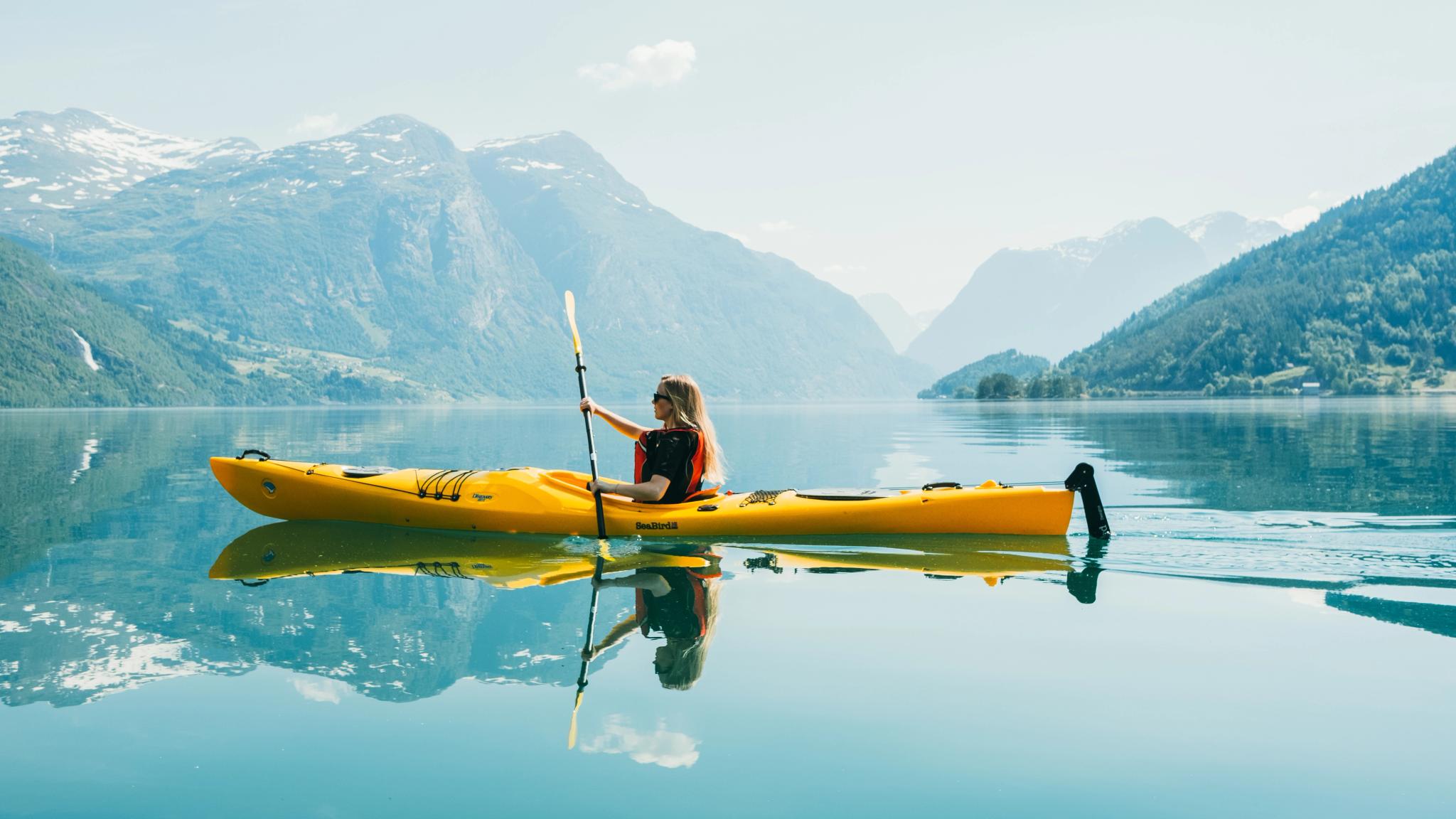 Woman kayaking on Lovatnet, Fjord Norway