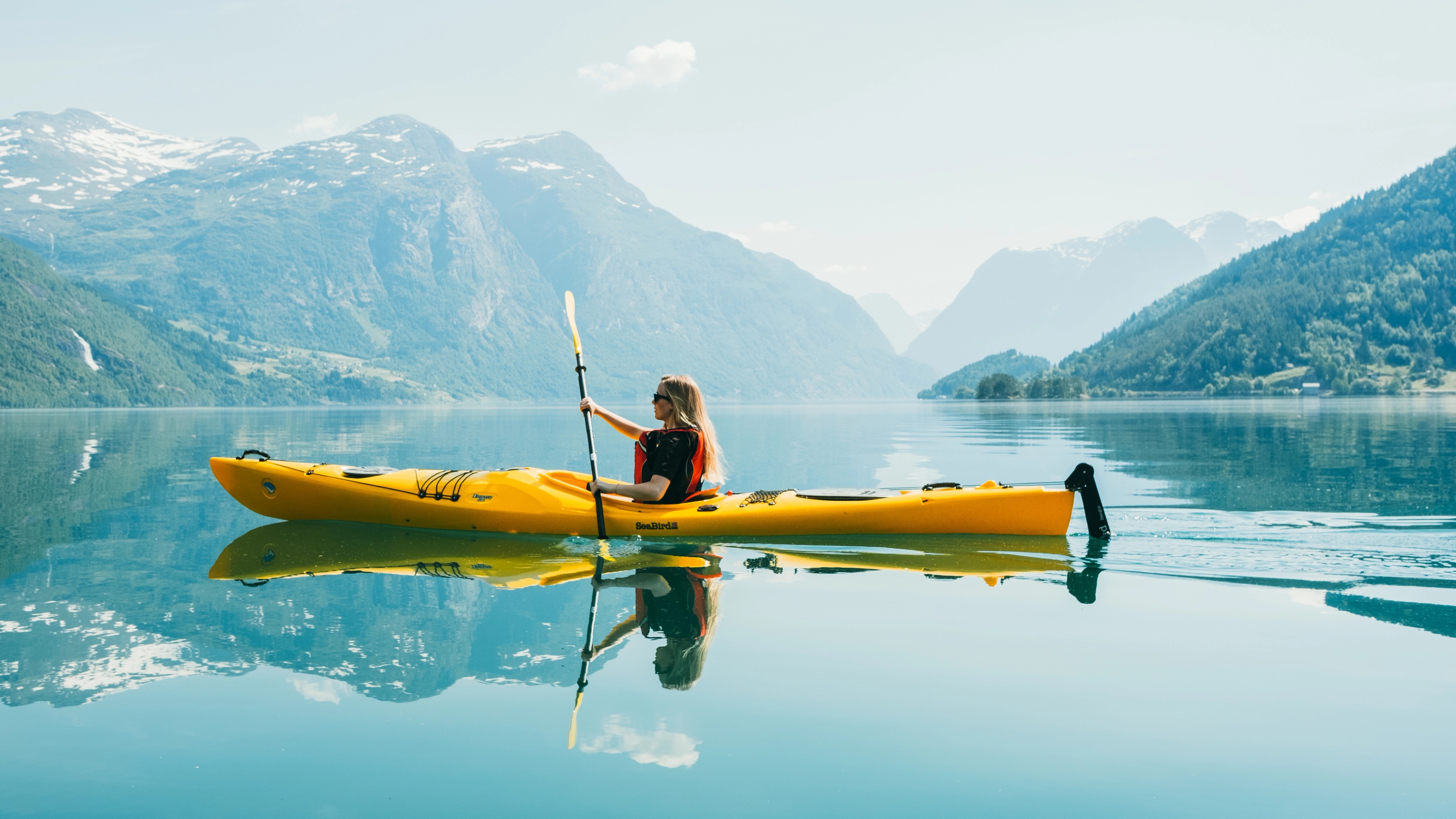 Woman kayaking on Lovatnet, Fjord Norway