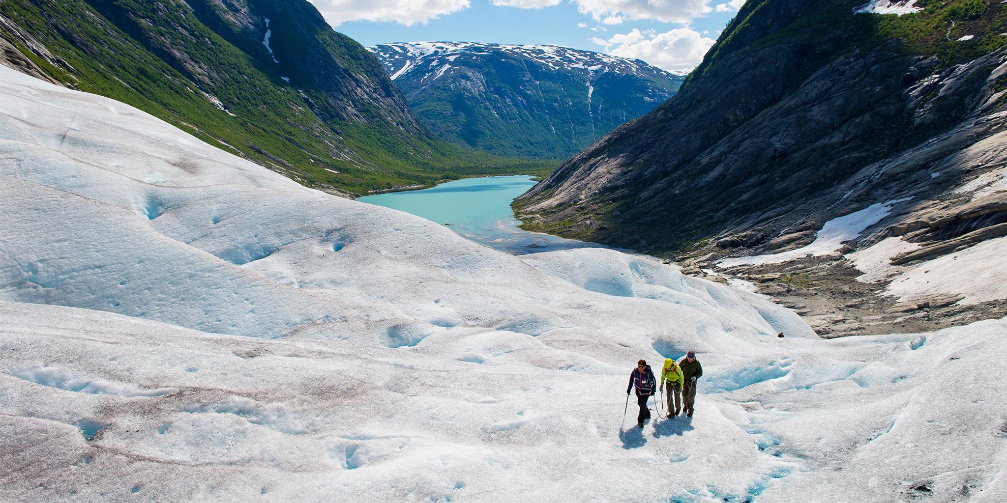 Tre personer går på brevandring på isbreen Nigardsbreen på Vestlandet