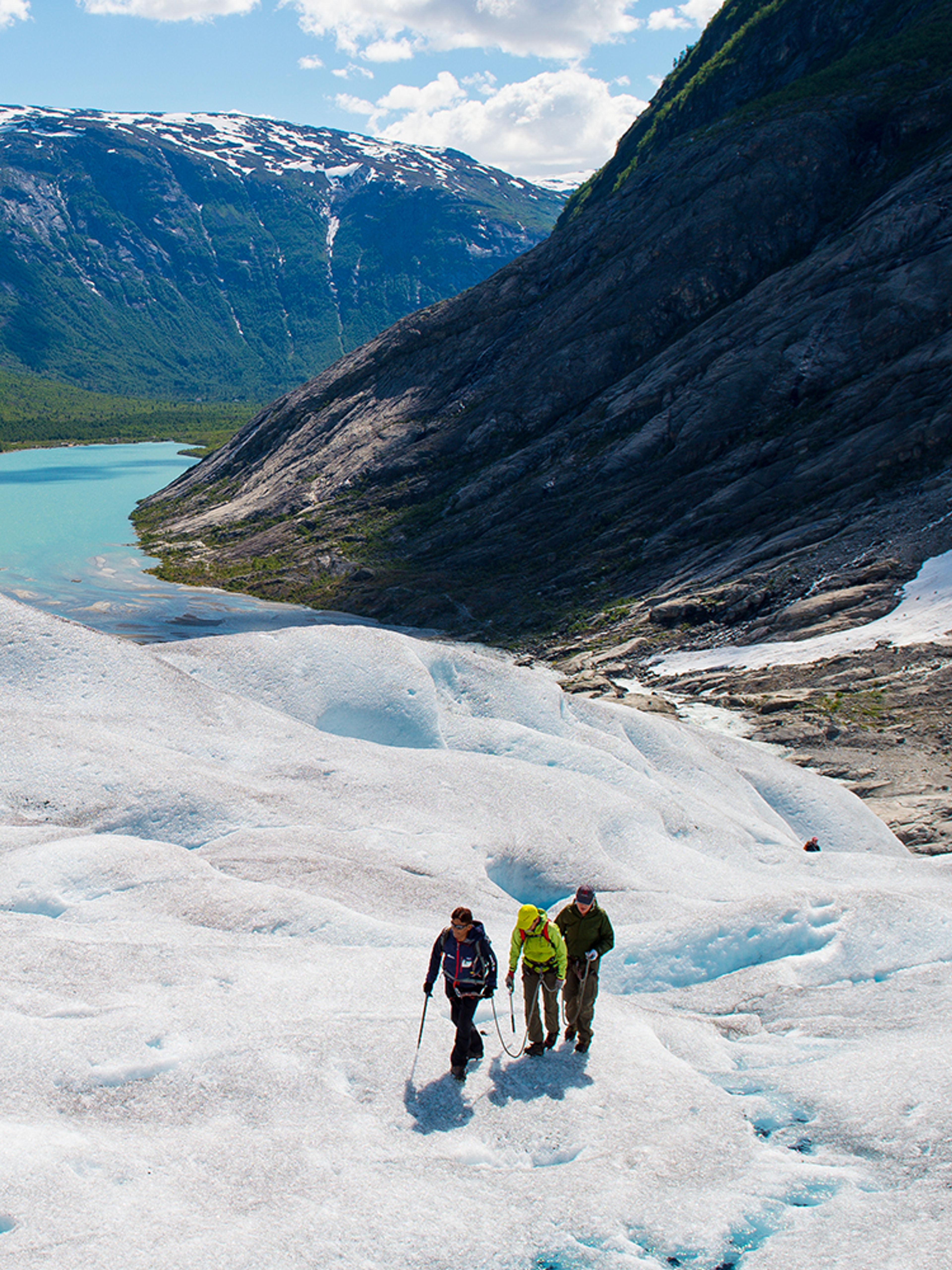 Three people hiking on the Nigardsbreen glacier in Fjord Norway