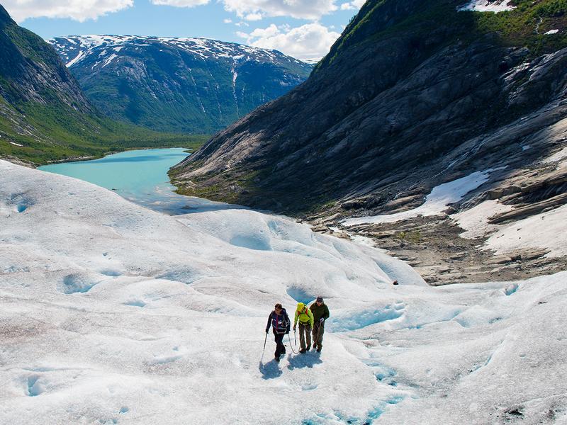 Drie mensen die over de Nigardsbreen-gletsjer wandelen in Fjord-Noorwegen