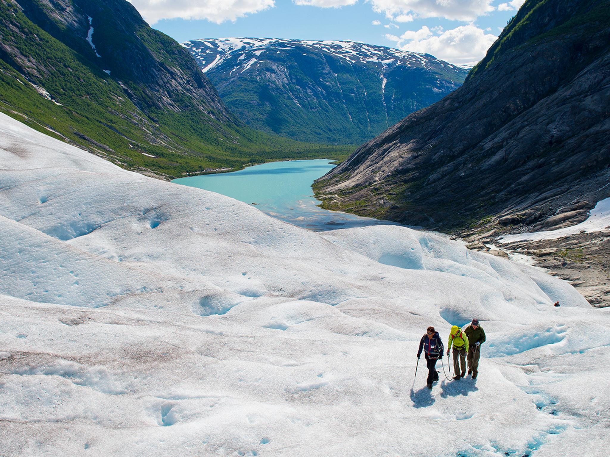 Tre personer på glaciärvandring på Nigardsbreen