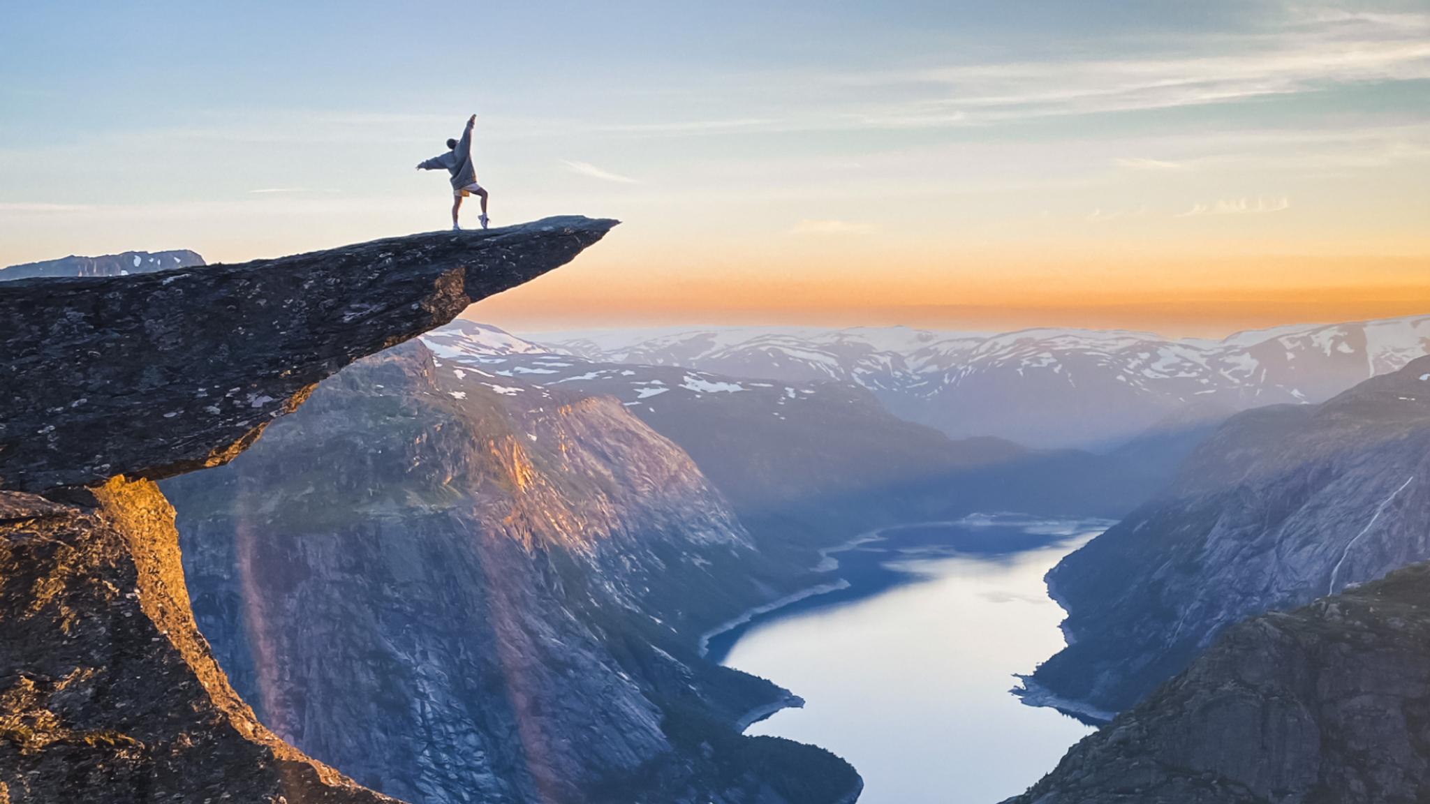 Person standing on Trolltunga in Odda, Fjord Norway