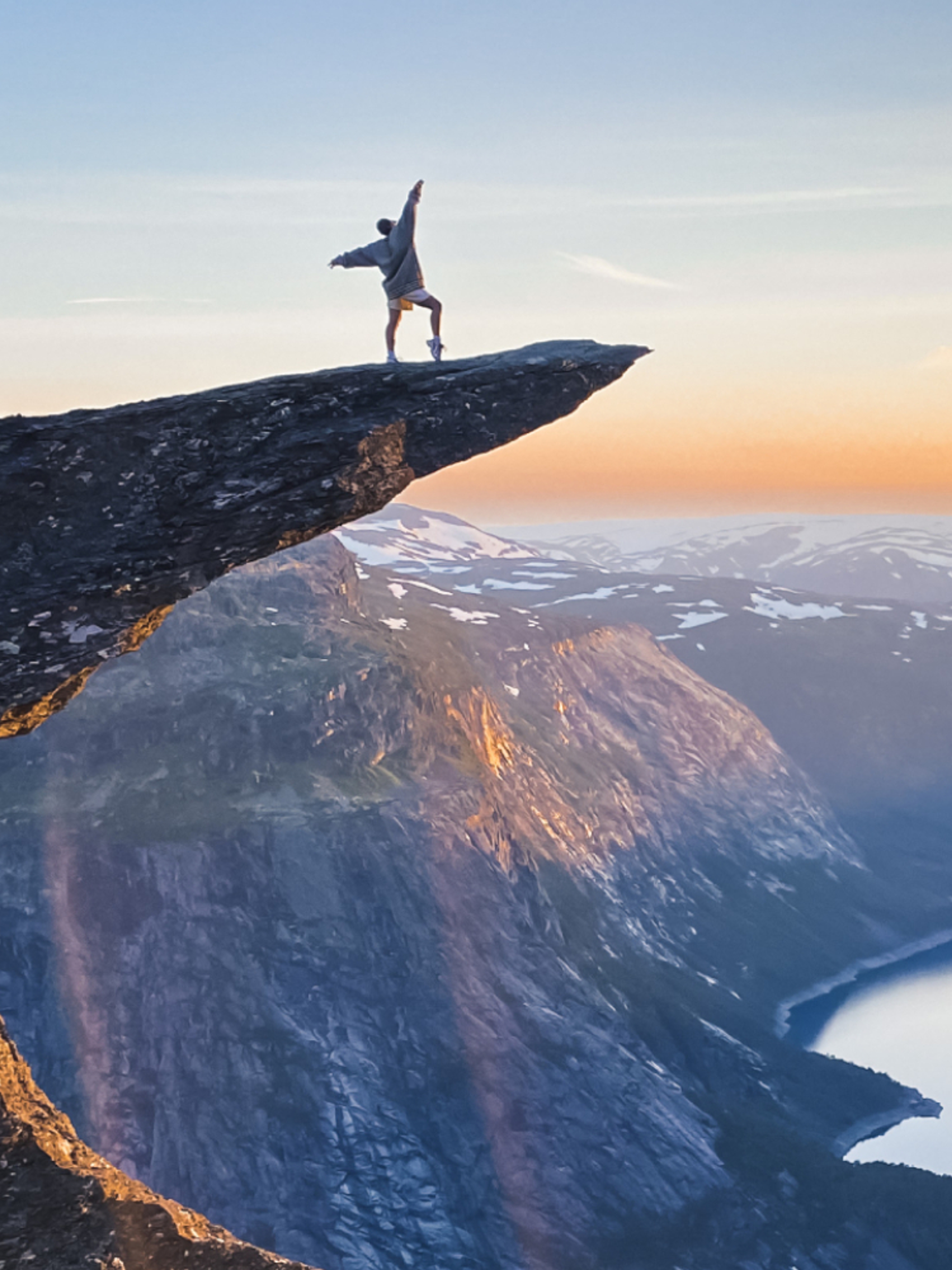 Person standing on Trolltunga in Odda, Fjord Norway