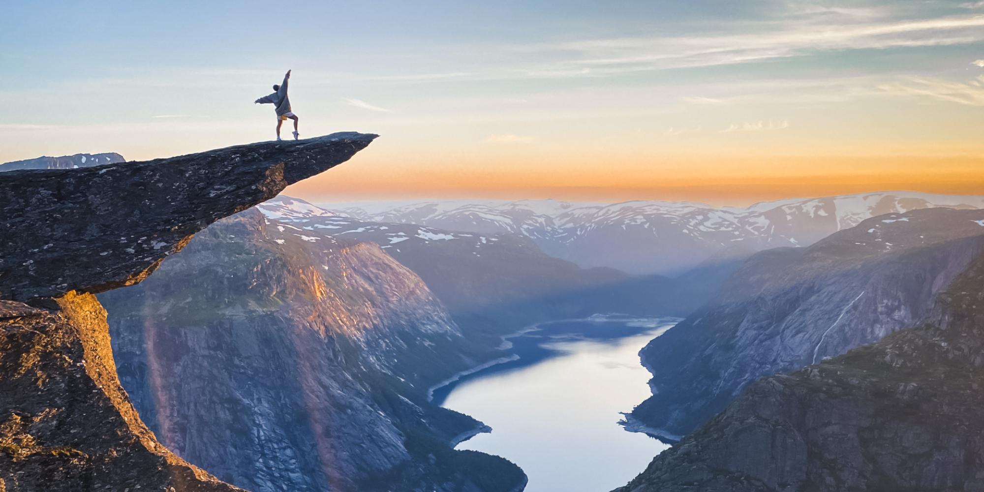 Person standing on Trolltunga in Odda, Fjord Norway