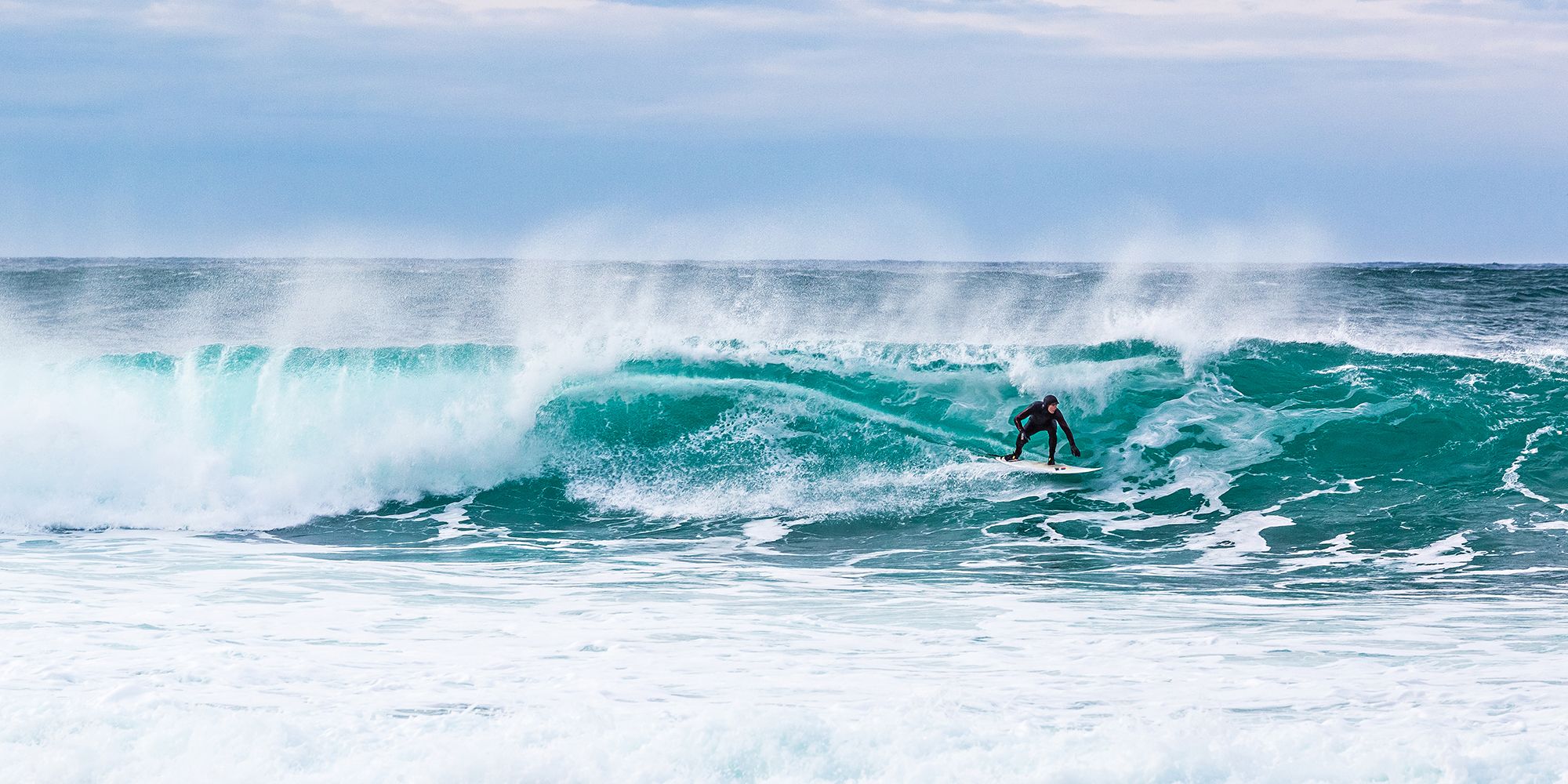Surfer riding a breaking wave at Unstad in Lofoten, Northern Norway