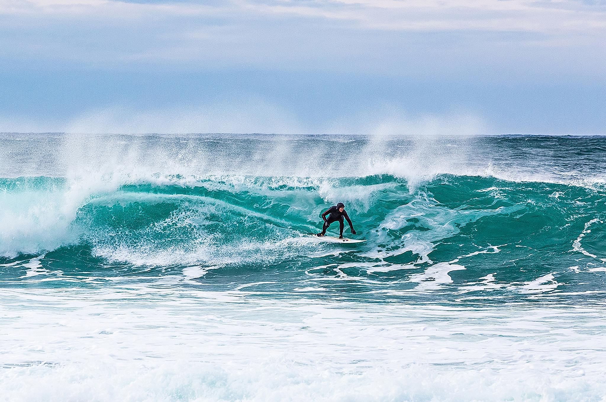 Ein Mann auf einer Welle in Unstad, Lofoten, Nordnorwegen