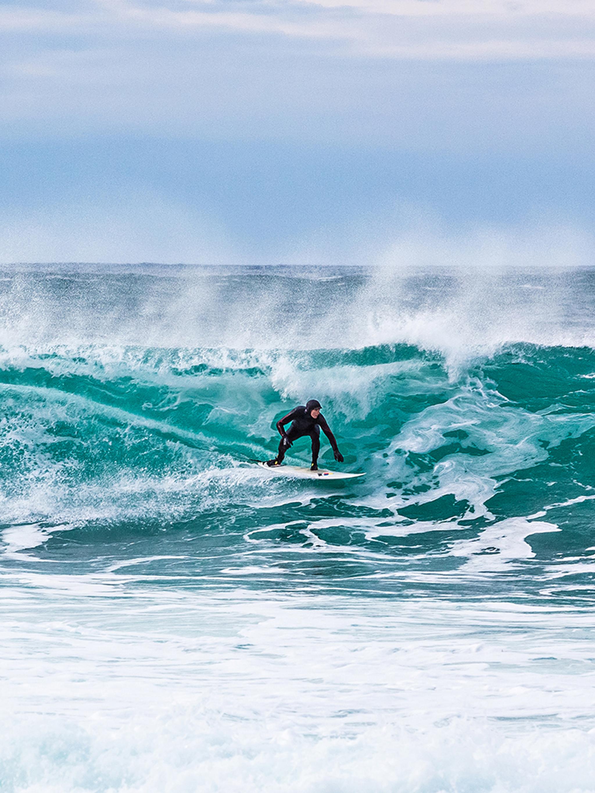 Surfer riding a breaking wave at Unstad in Lofoten, Northern Norway