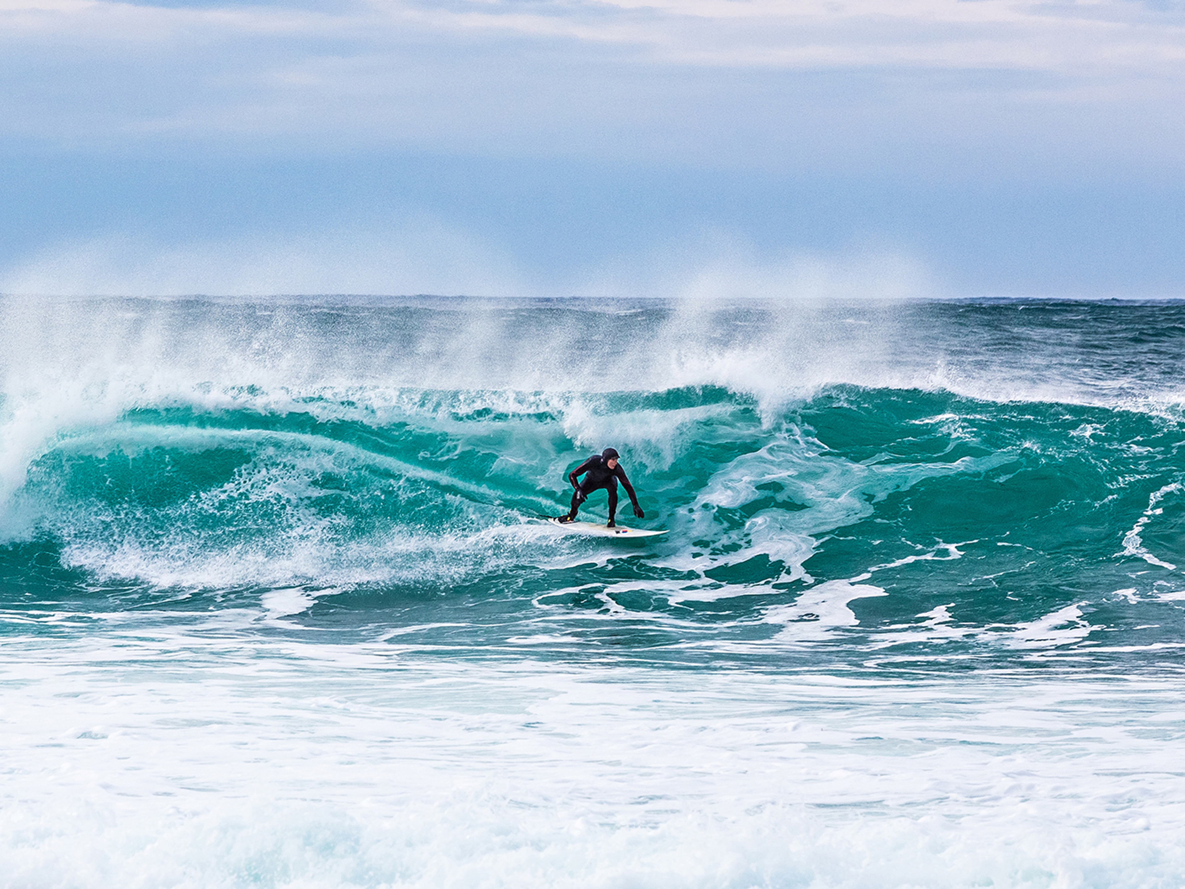 Surfer riding a breaking wave at Unstad in Lofoten, Northern Norway