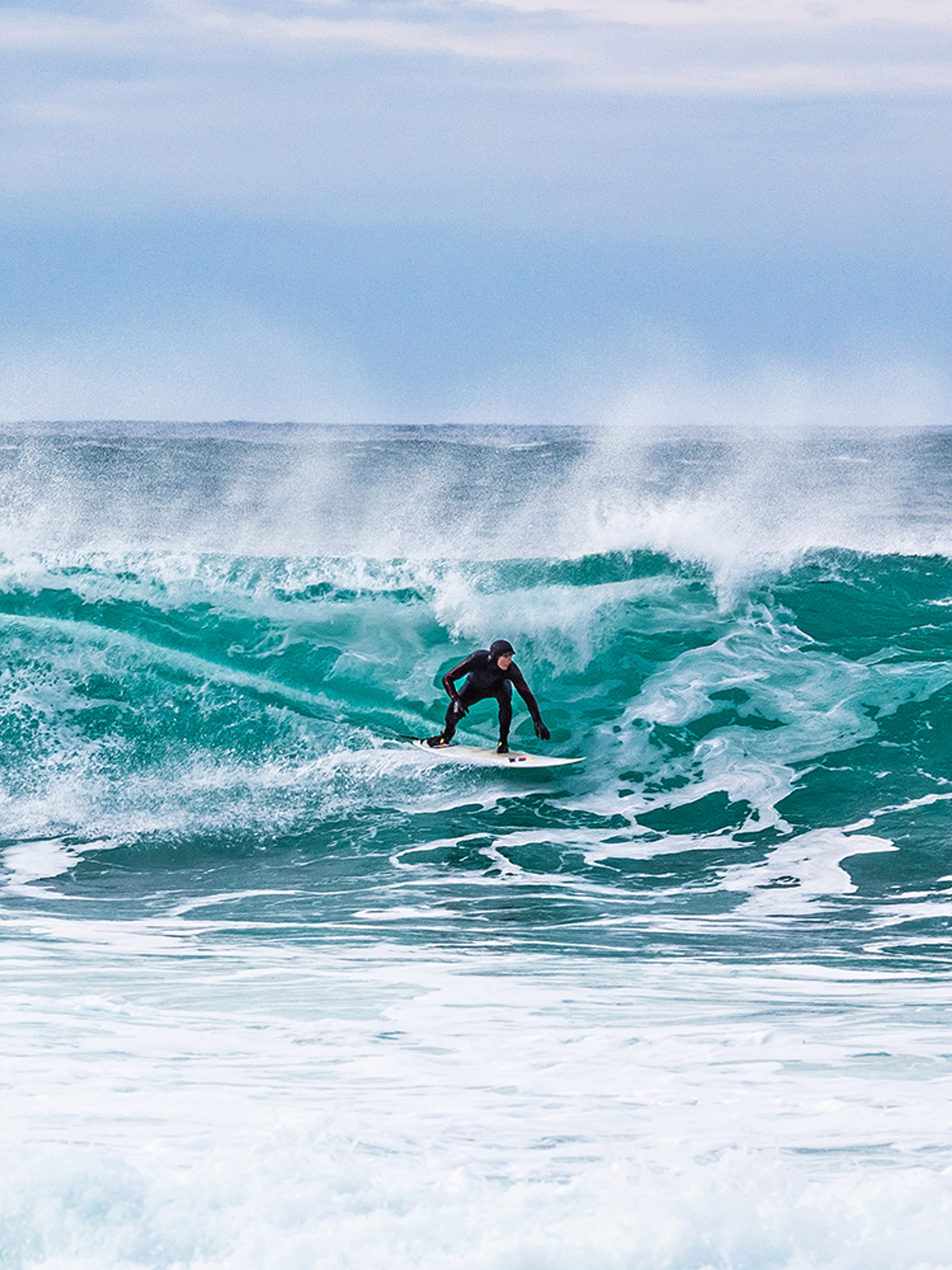 Surfer riding a breaking wave at Unstad in Lofoten, Northern Norway