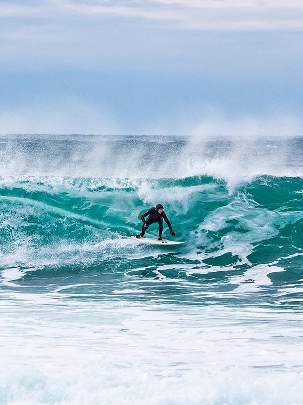 Surfer riding a breaking wave at Unstad in Lofoten, Northern Norway