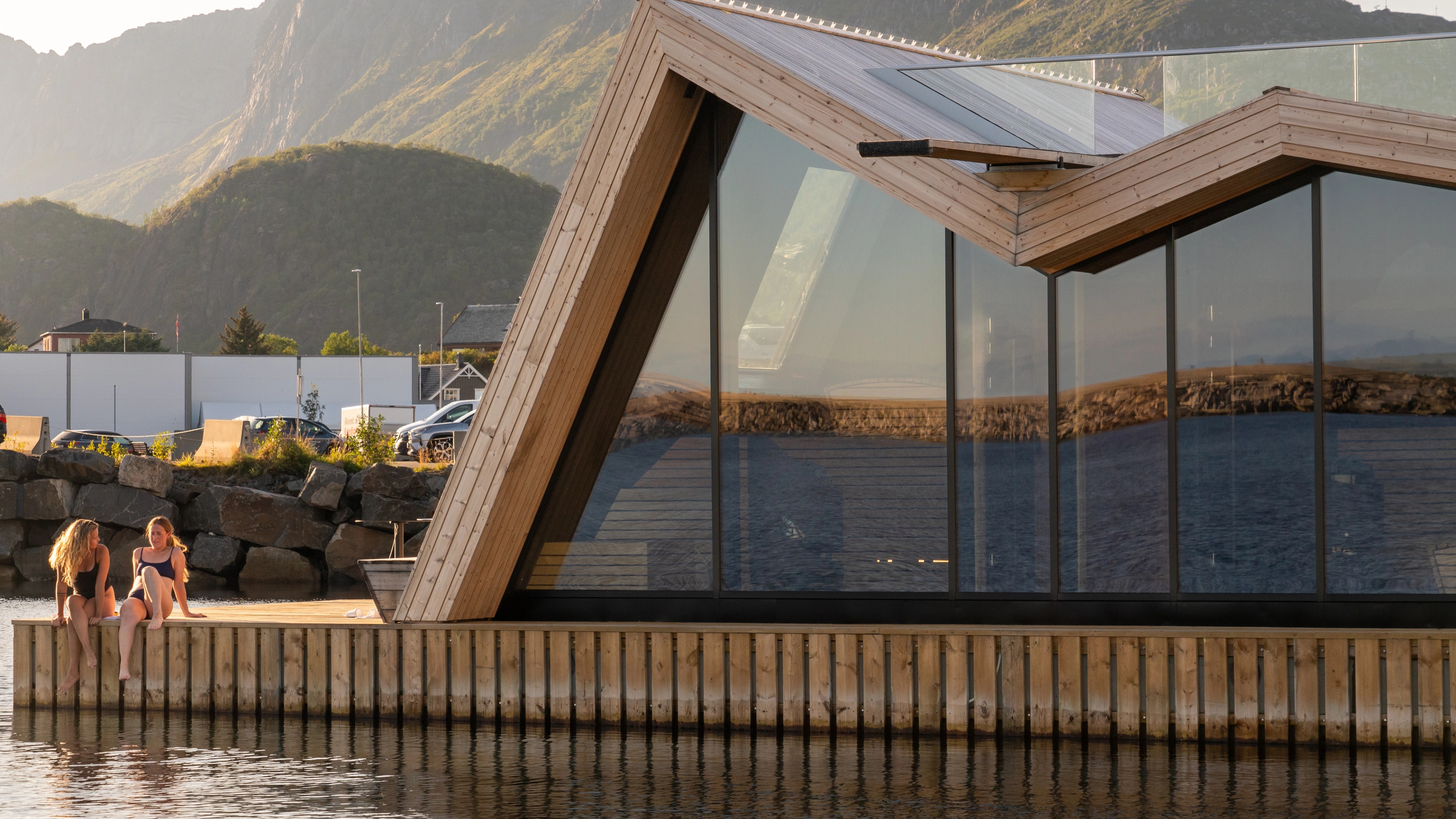 To personer sitter utenfor en flytende badstu i Svolvær i Lofoten