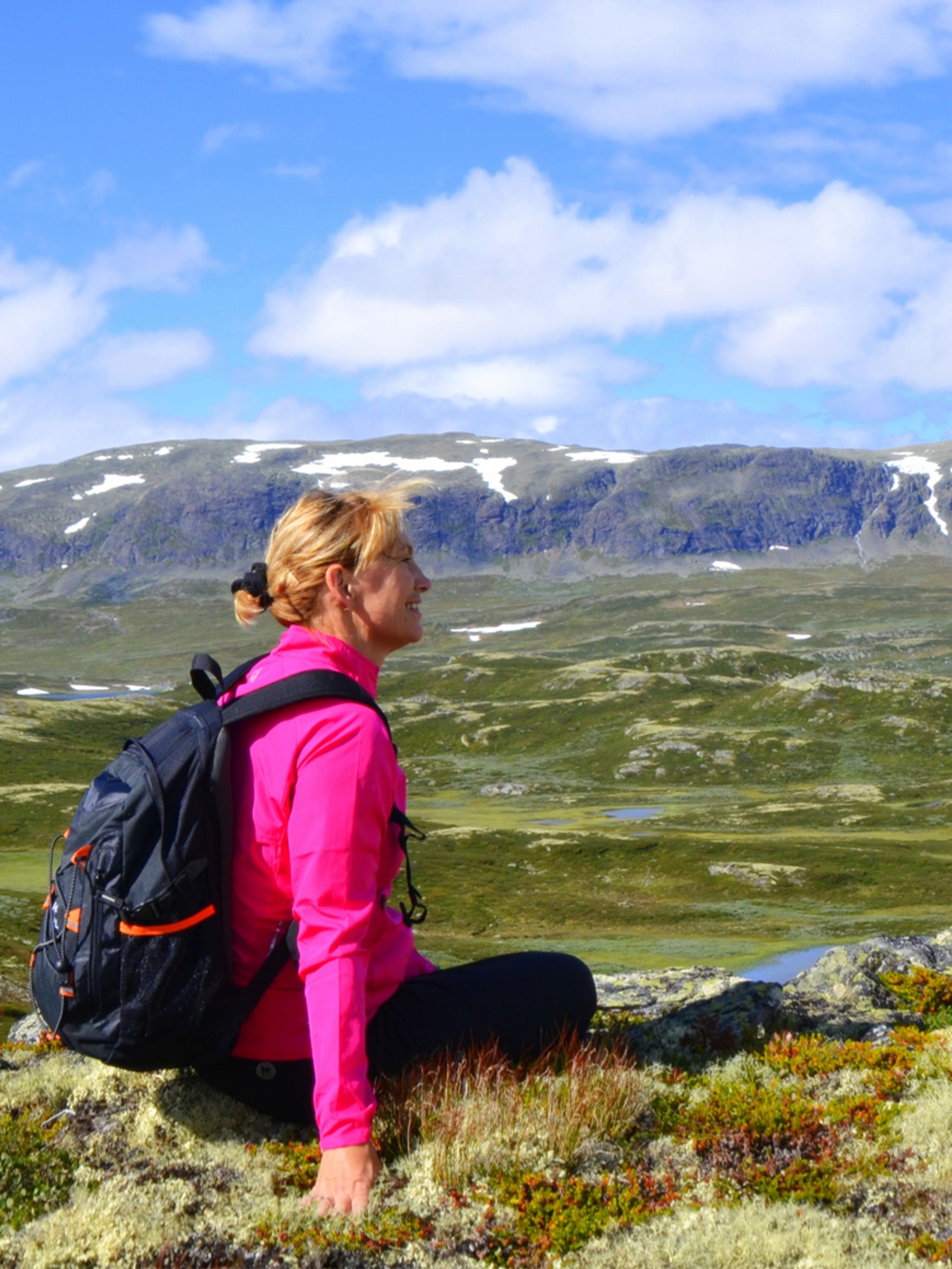 A woman sitting and enjoying the view of the mountains in Ål in Hallingdal, Eastern Norway