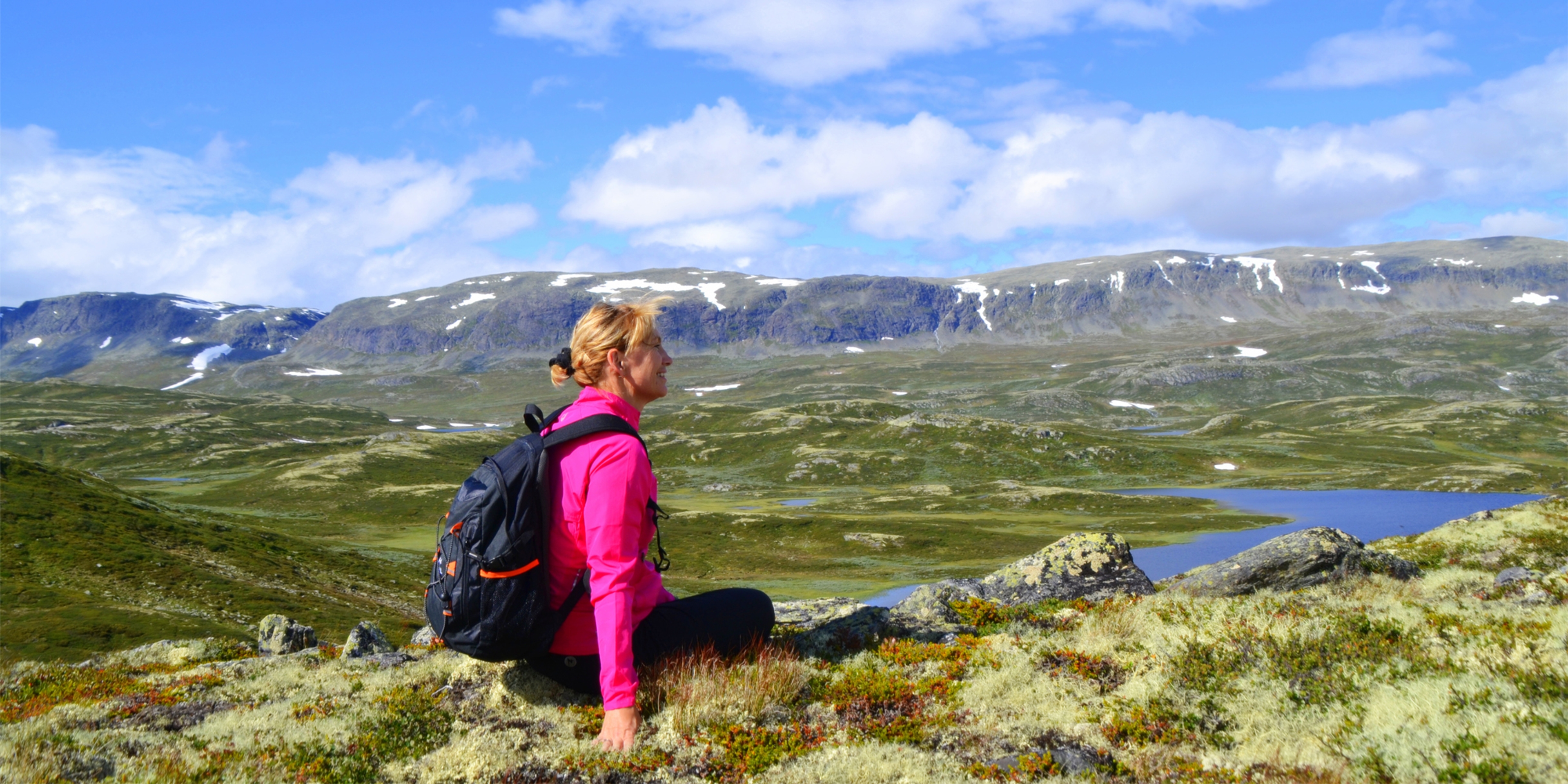Una donna è seduta ad ammirare la vista sulle montagne a Ål nella Hallingdal, Norvegia orientale