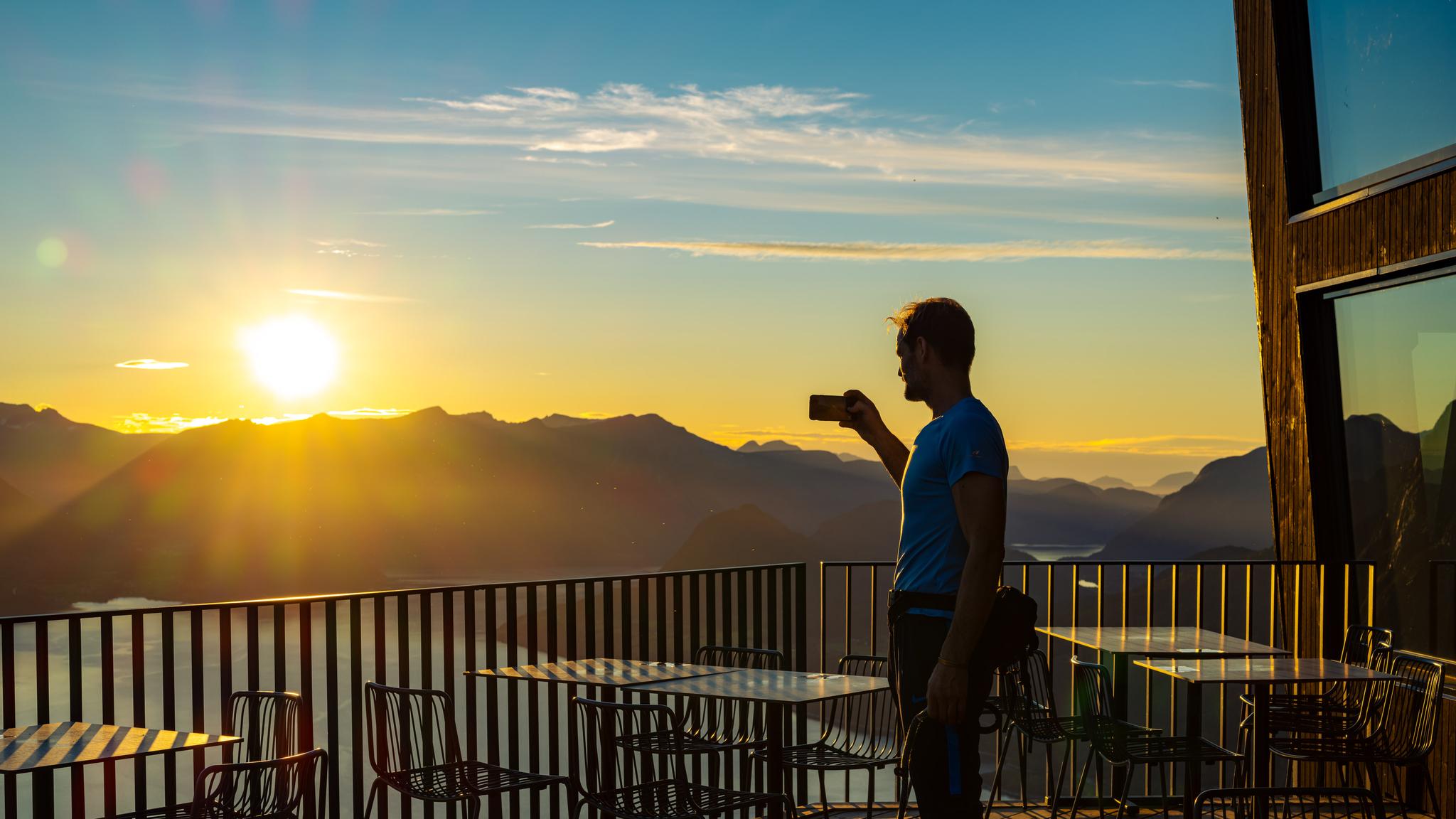A man looks at the sunset from Eggen restaurant in Åndalsnes, Norway