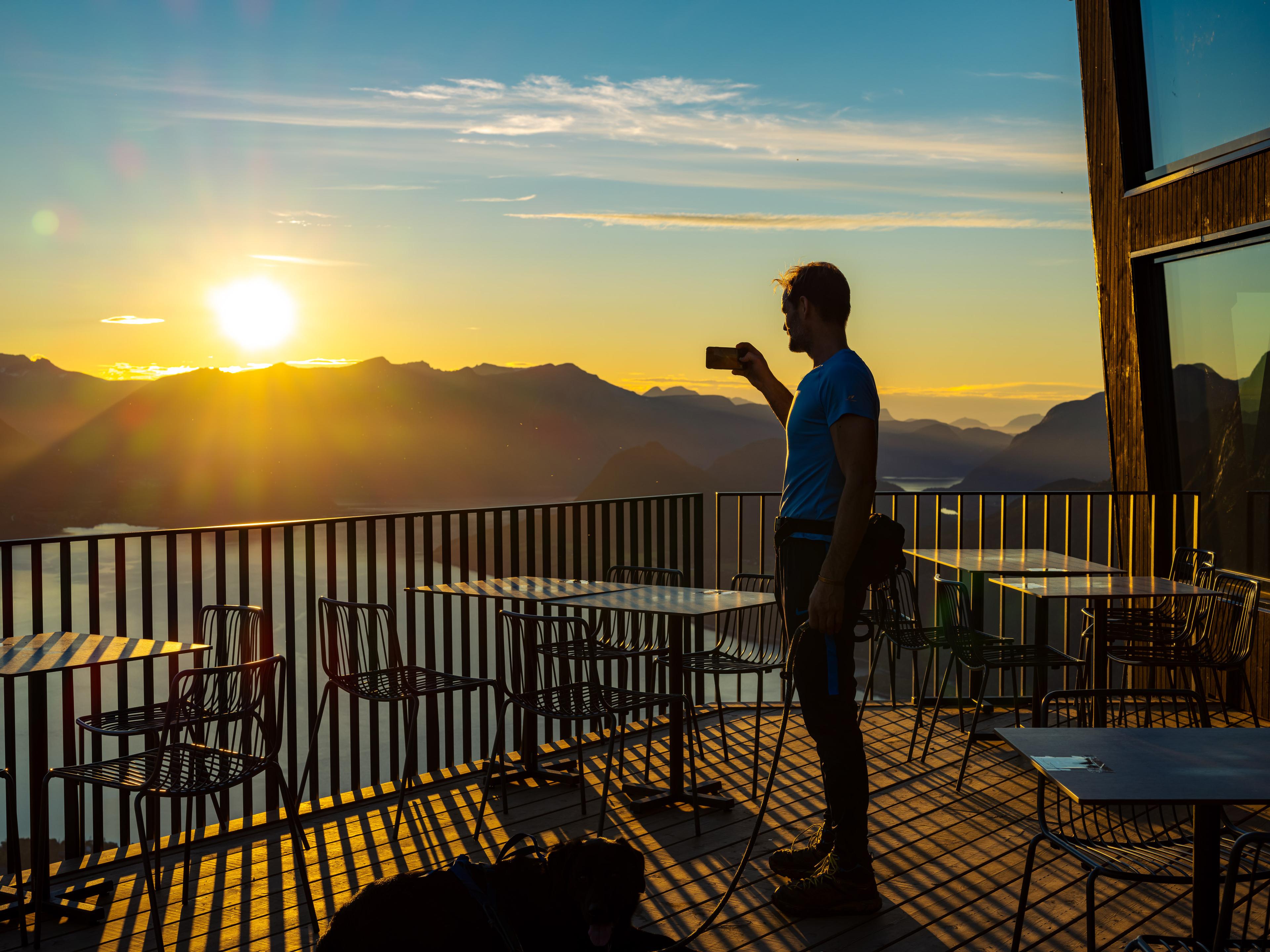 A man looks at the sunset from Eggen restaurant in Åndalsnes, Norway