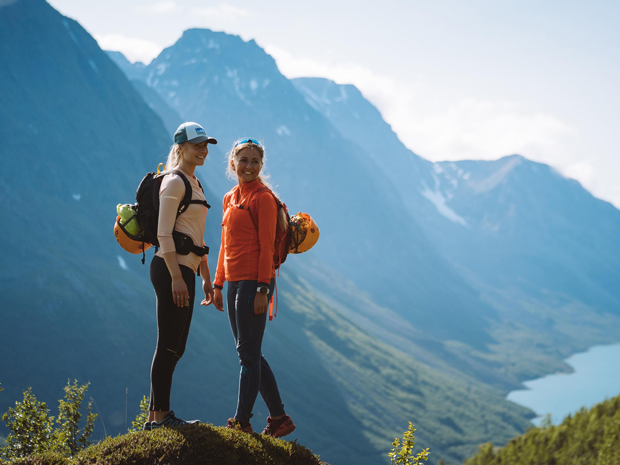 Zwei Frauen wandern an einem sonnigen Sommertag in den Bergen um Tromsø in Nordnorwegen