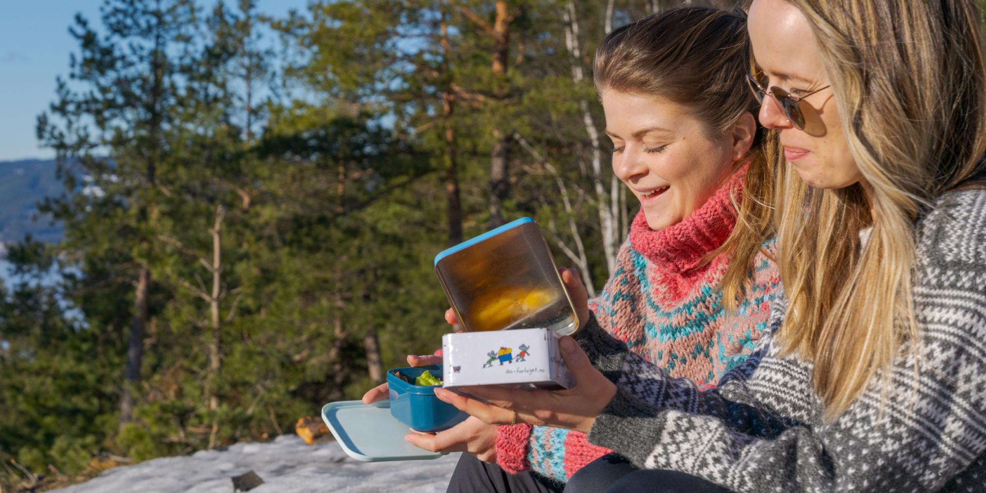 Two girls eating lunch with a view at Grefsenkollen viewpoint in Oslo