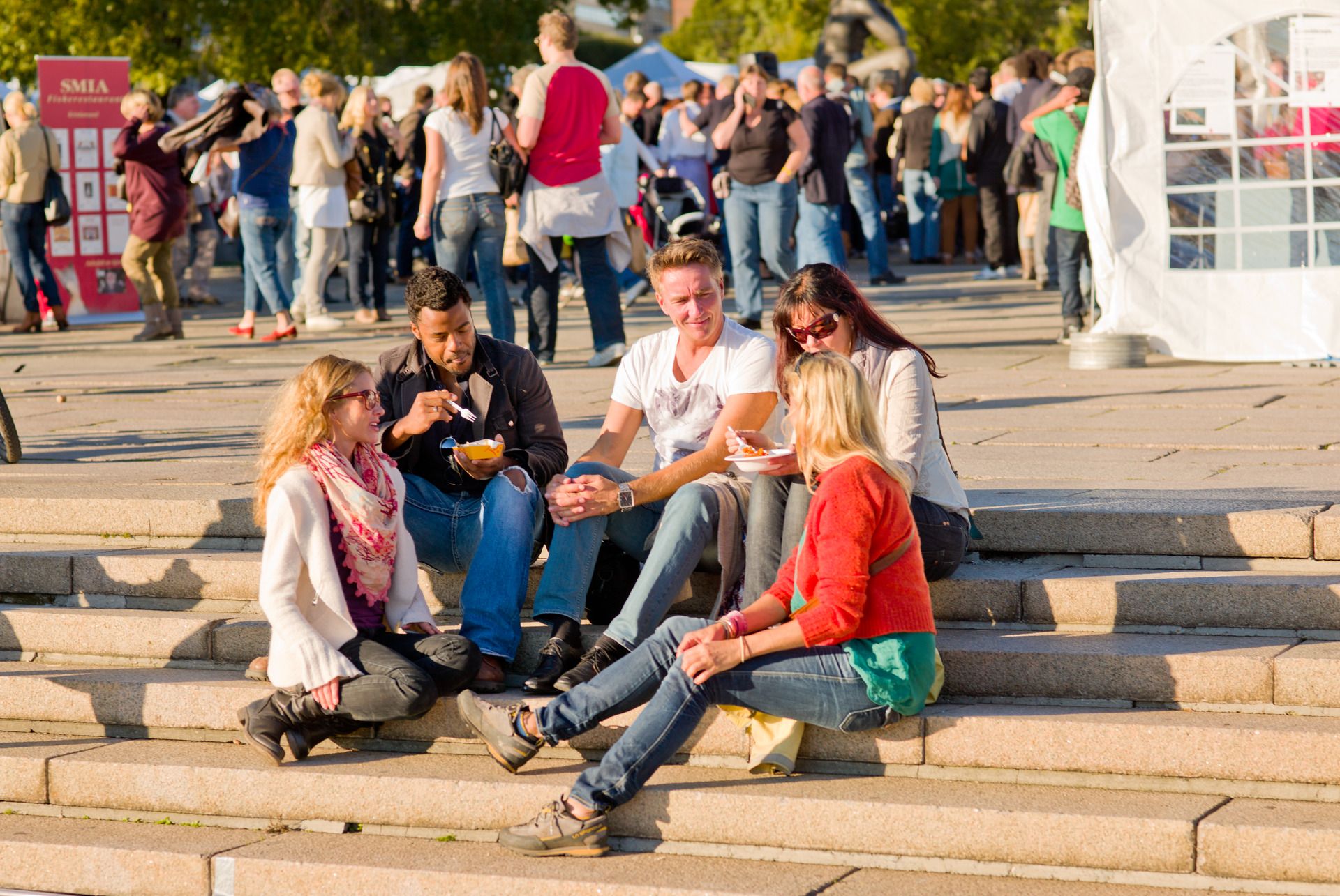 People enjoy food in the sunshine at a food festival