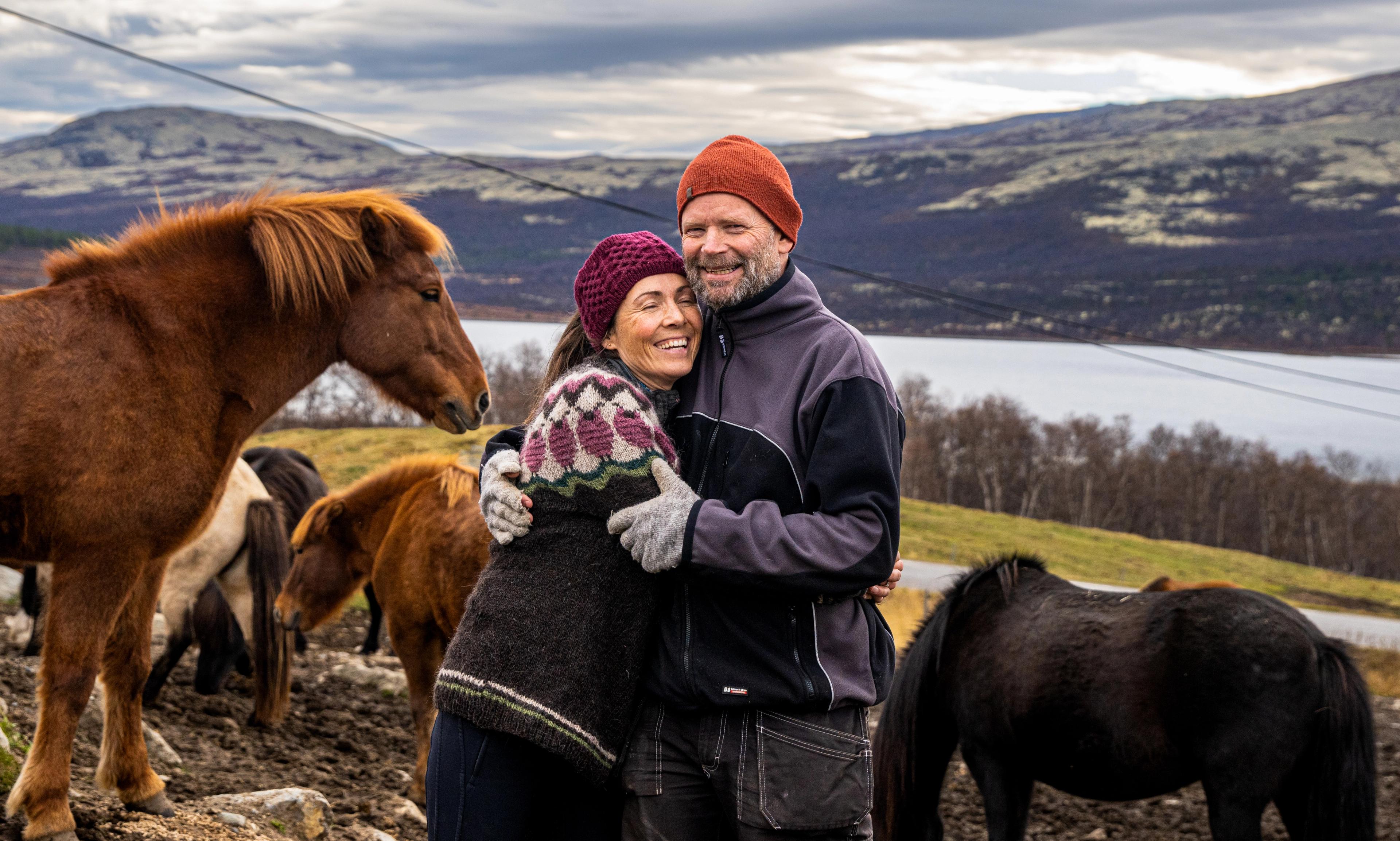 Two people standing with horses at Hjerkinn