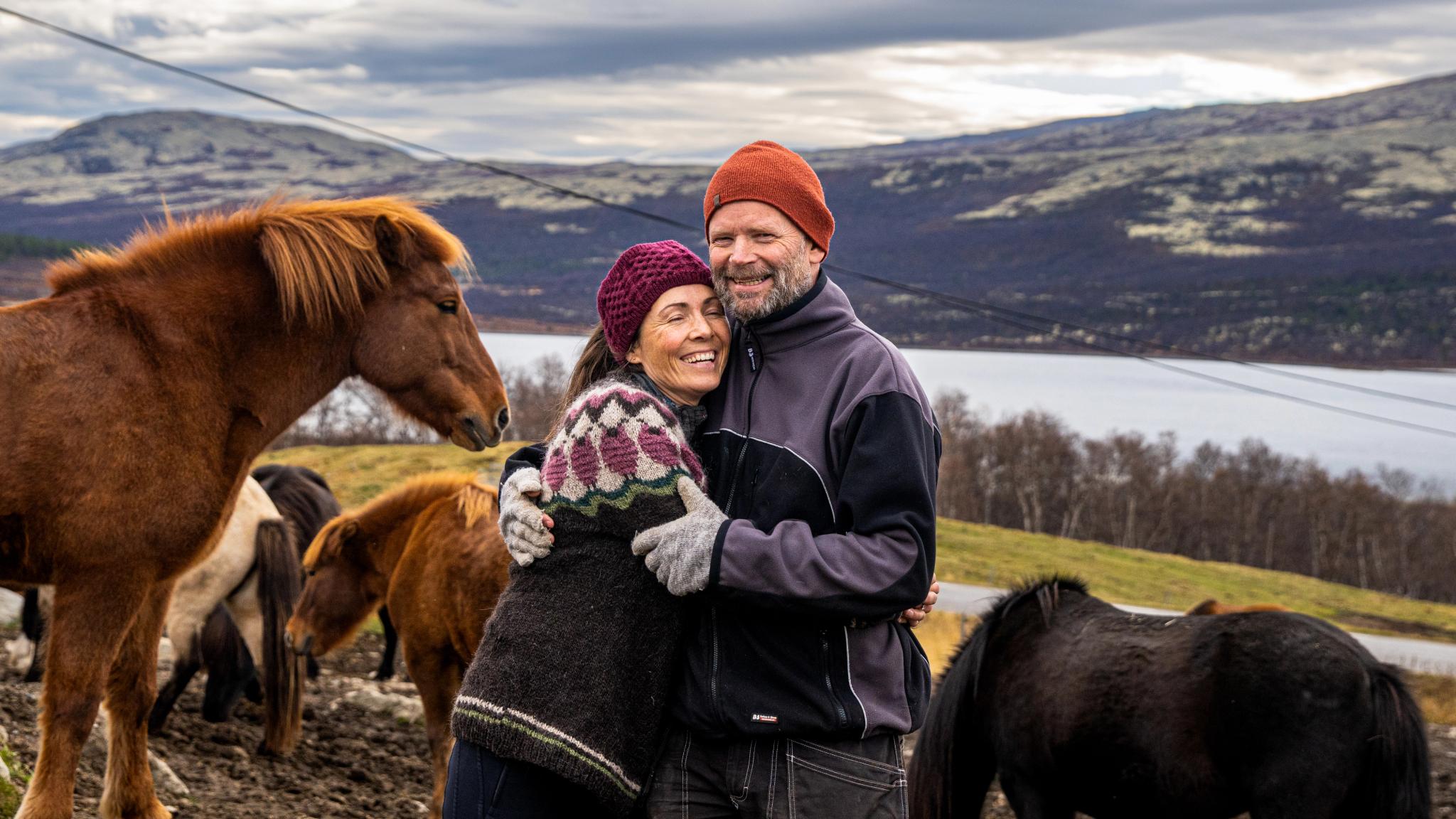 Two people standing with horses at Hjerkinn