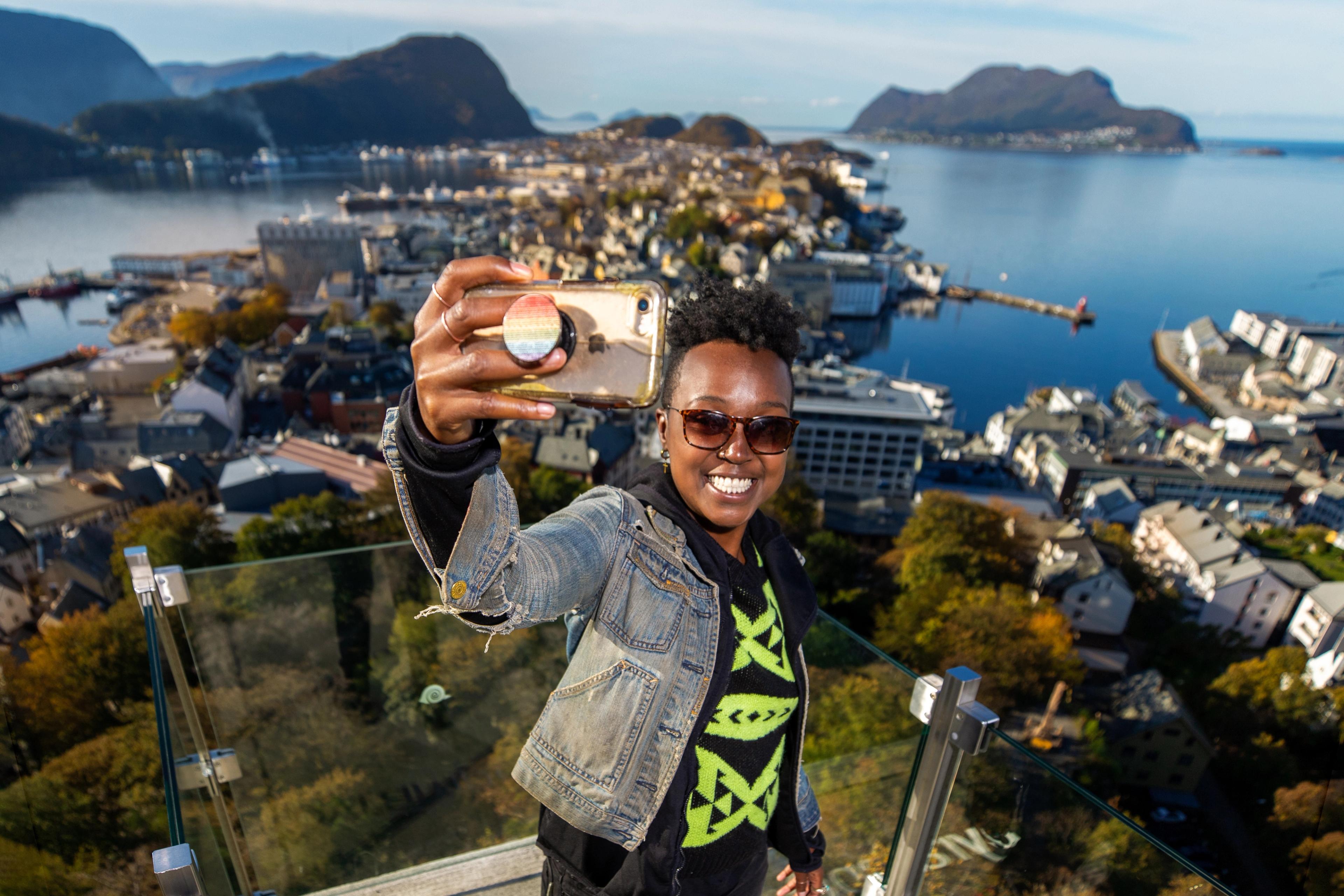A woman taking a selfie at Aksla in Ålesund, Norway