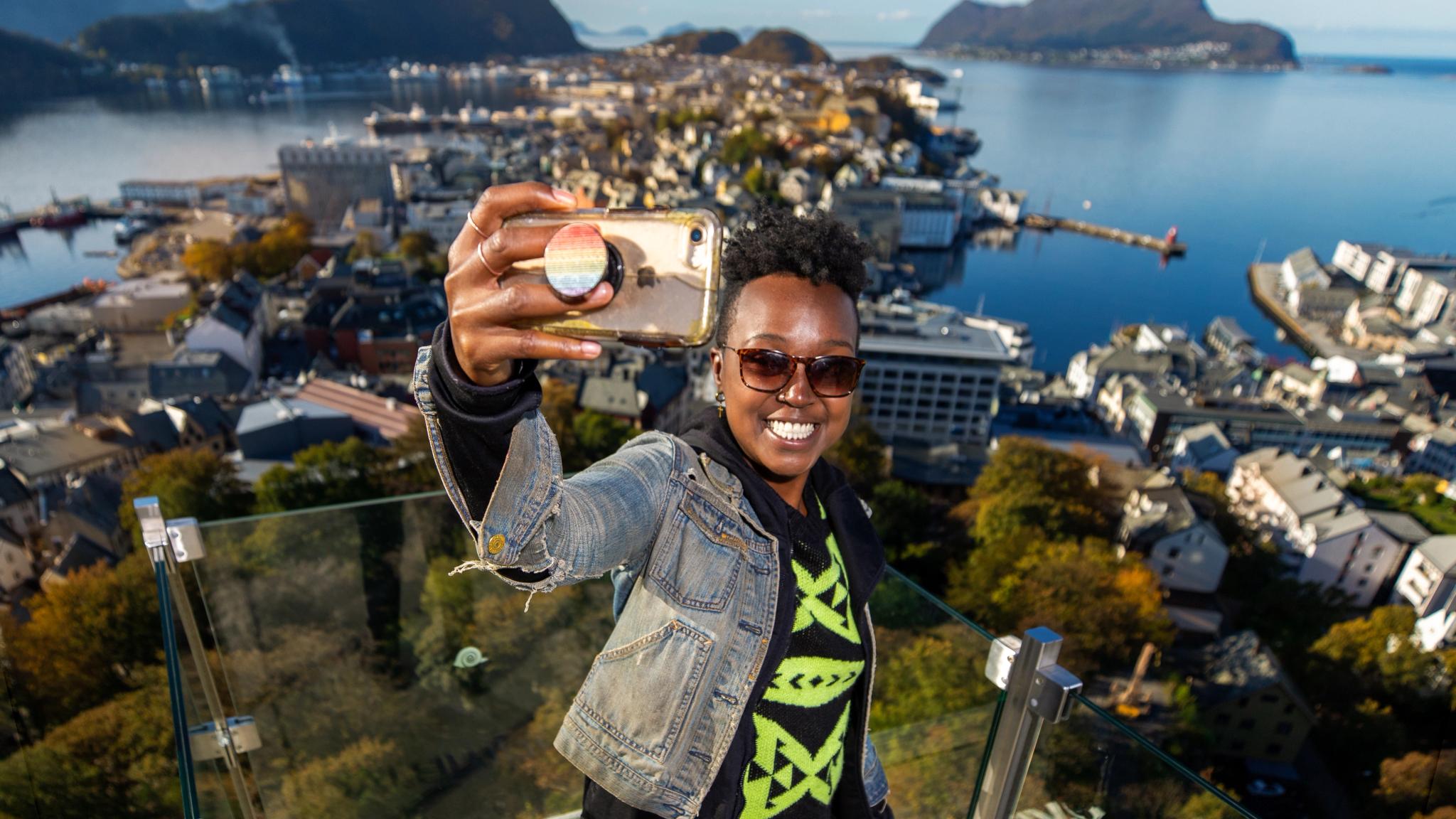 A woman taking a selfie at Aksla in Ålesund, Norway
