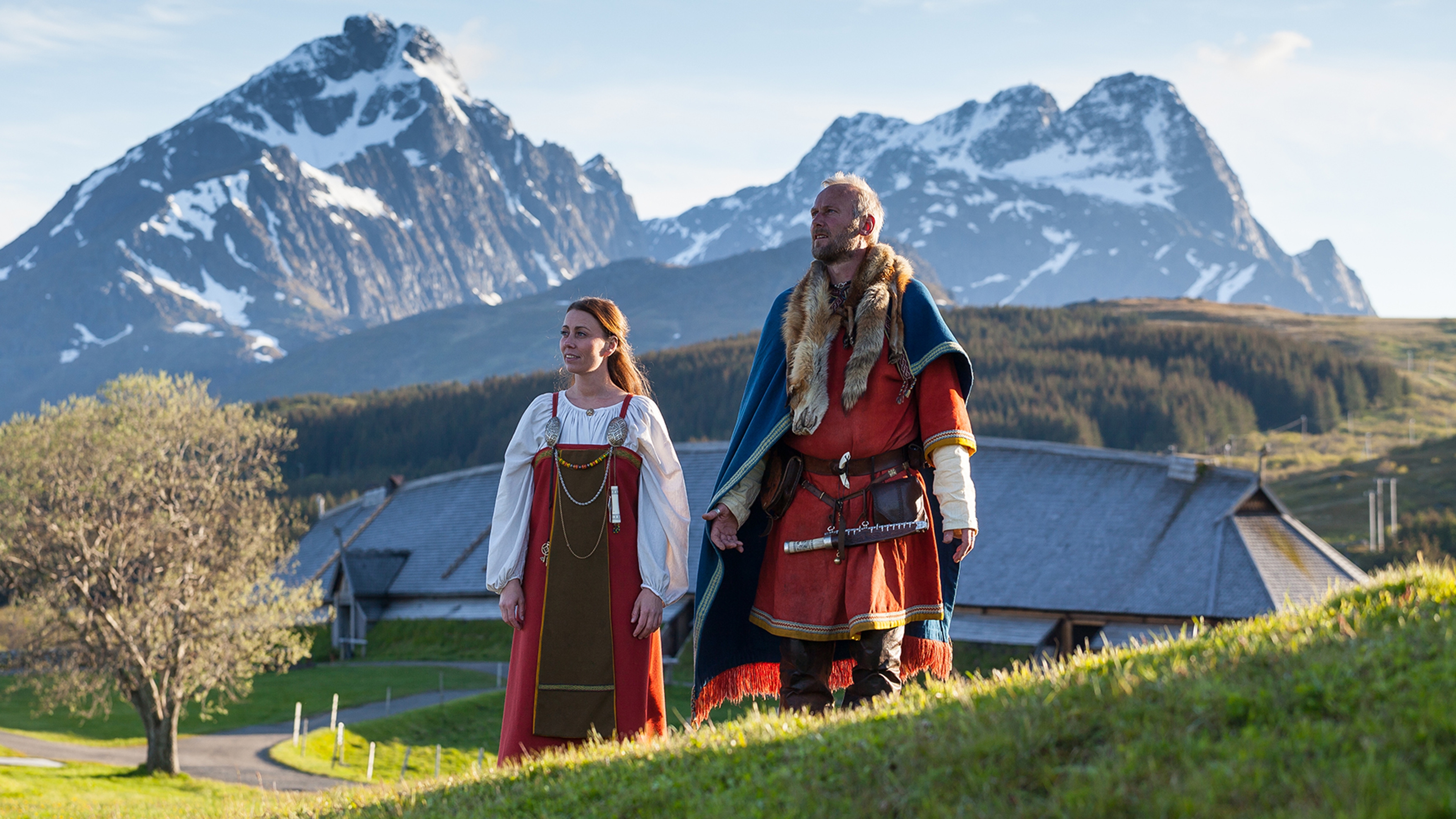 Two vikings standing in front of the main house at Lofotr Viking museum in Lofoten