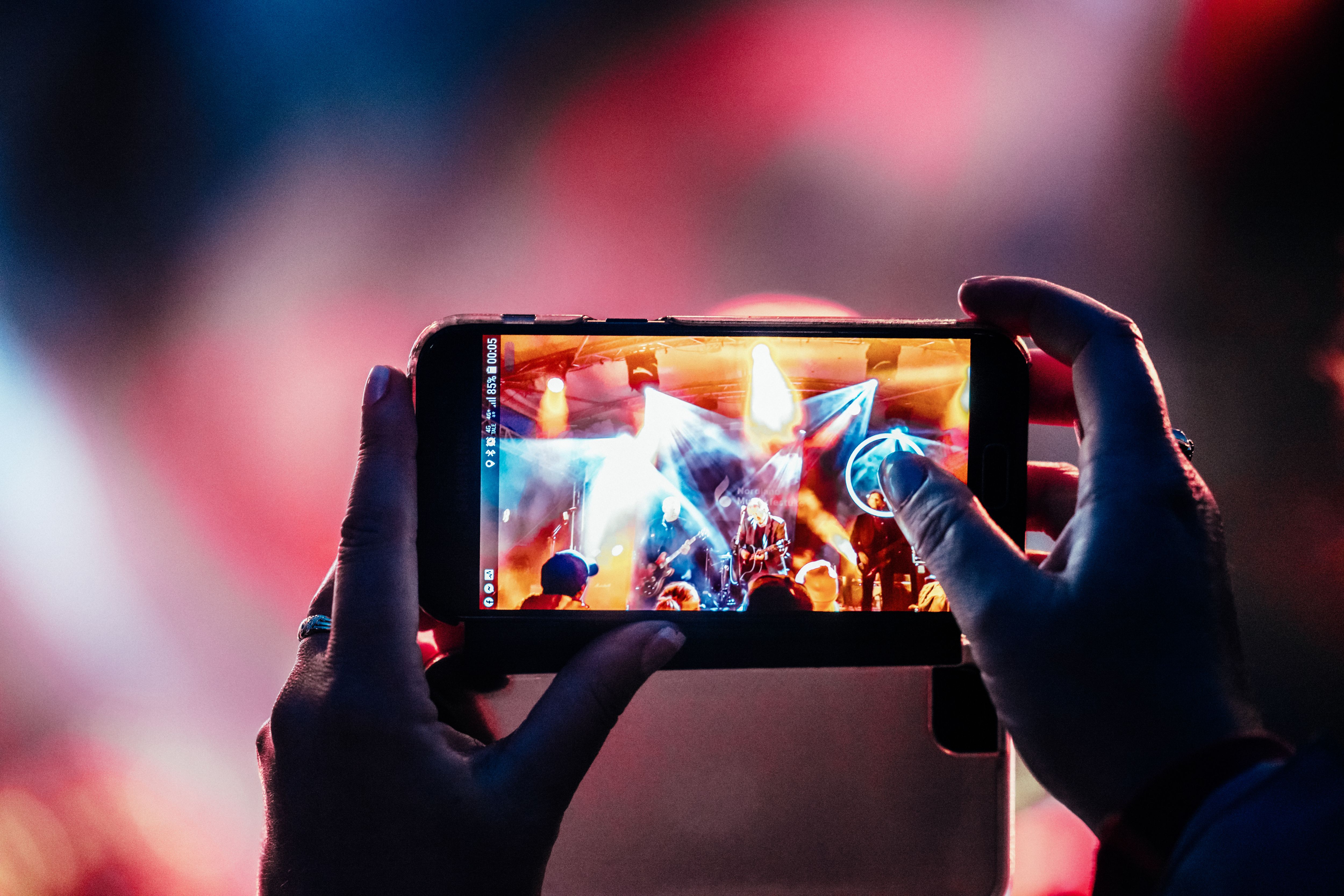 A person taking a picture of a consert.