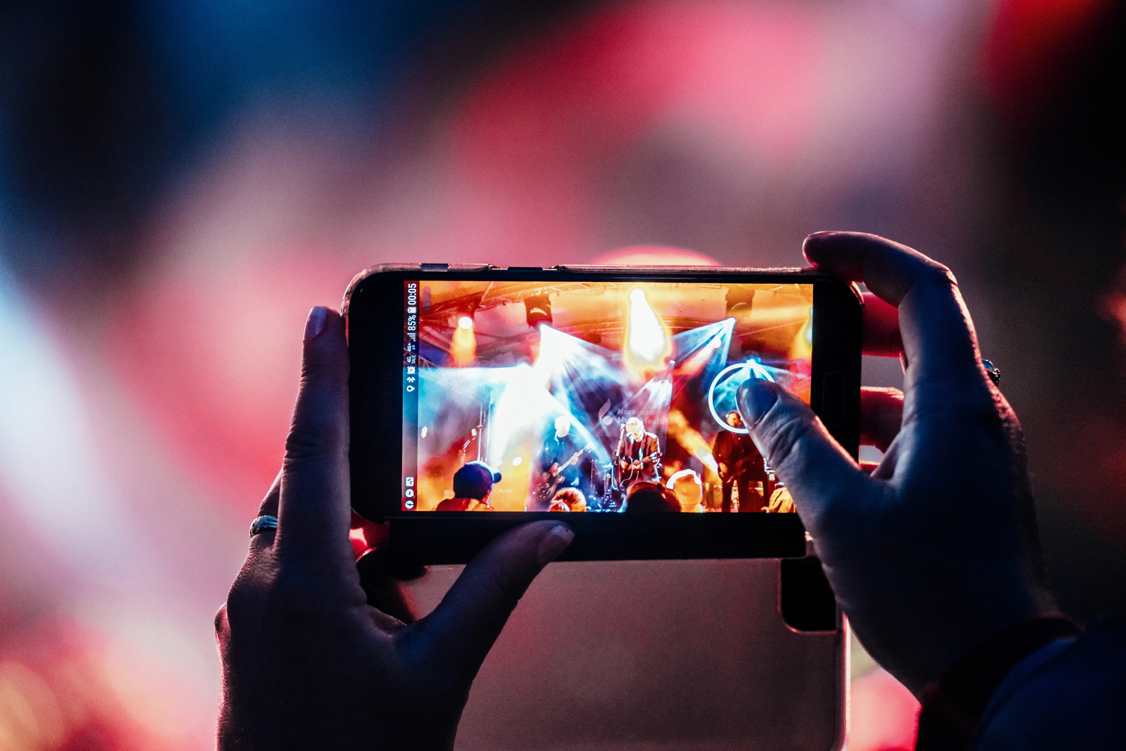 A person taking a picture of a consert.