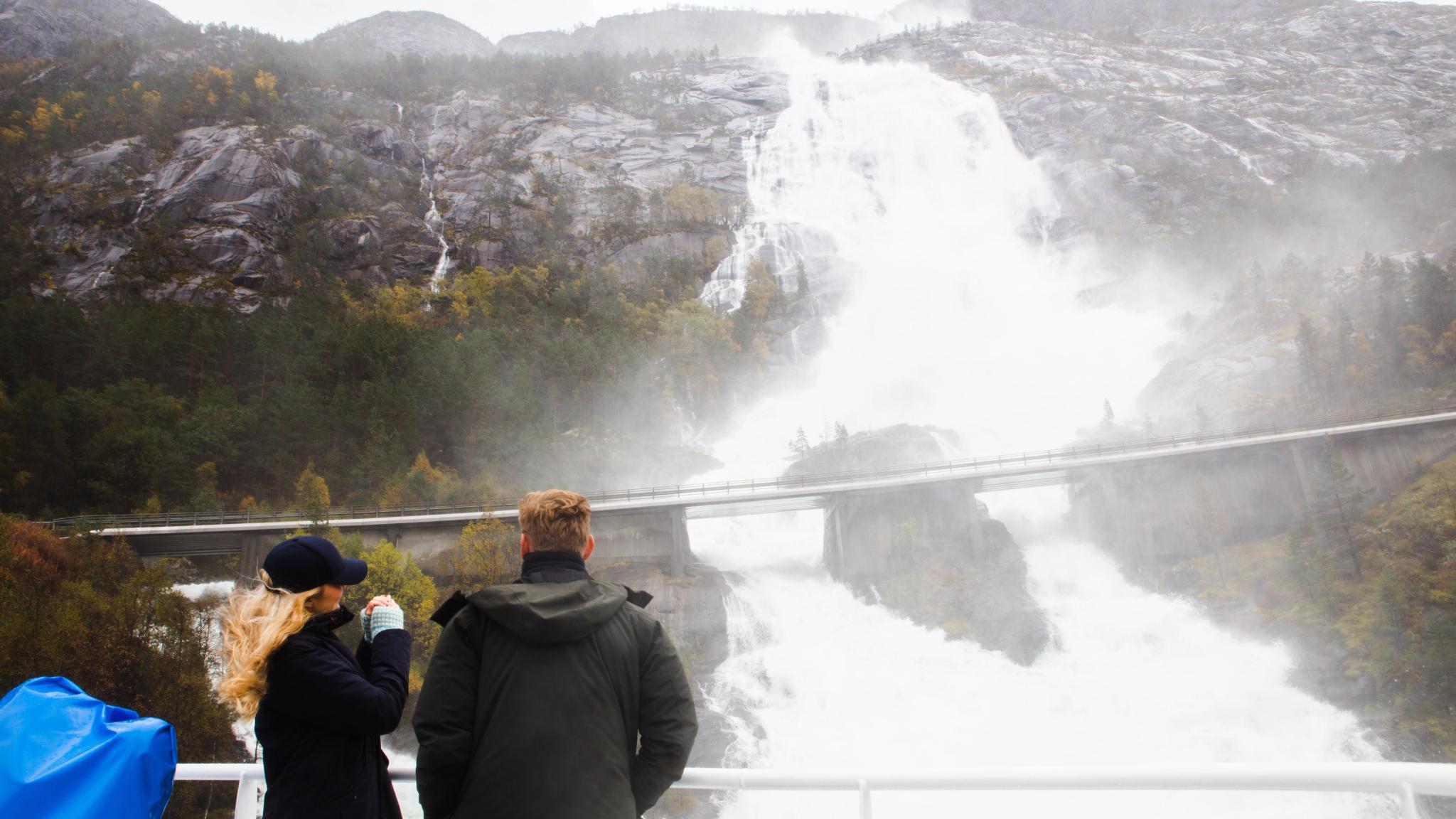 Two people enjoying the view of Langfoss in Åkrafjorden