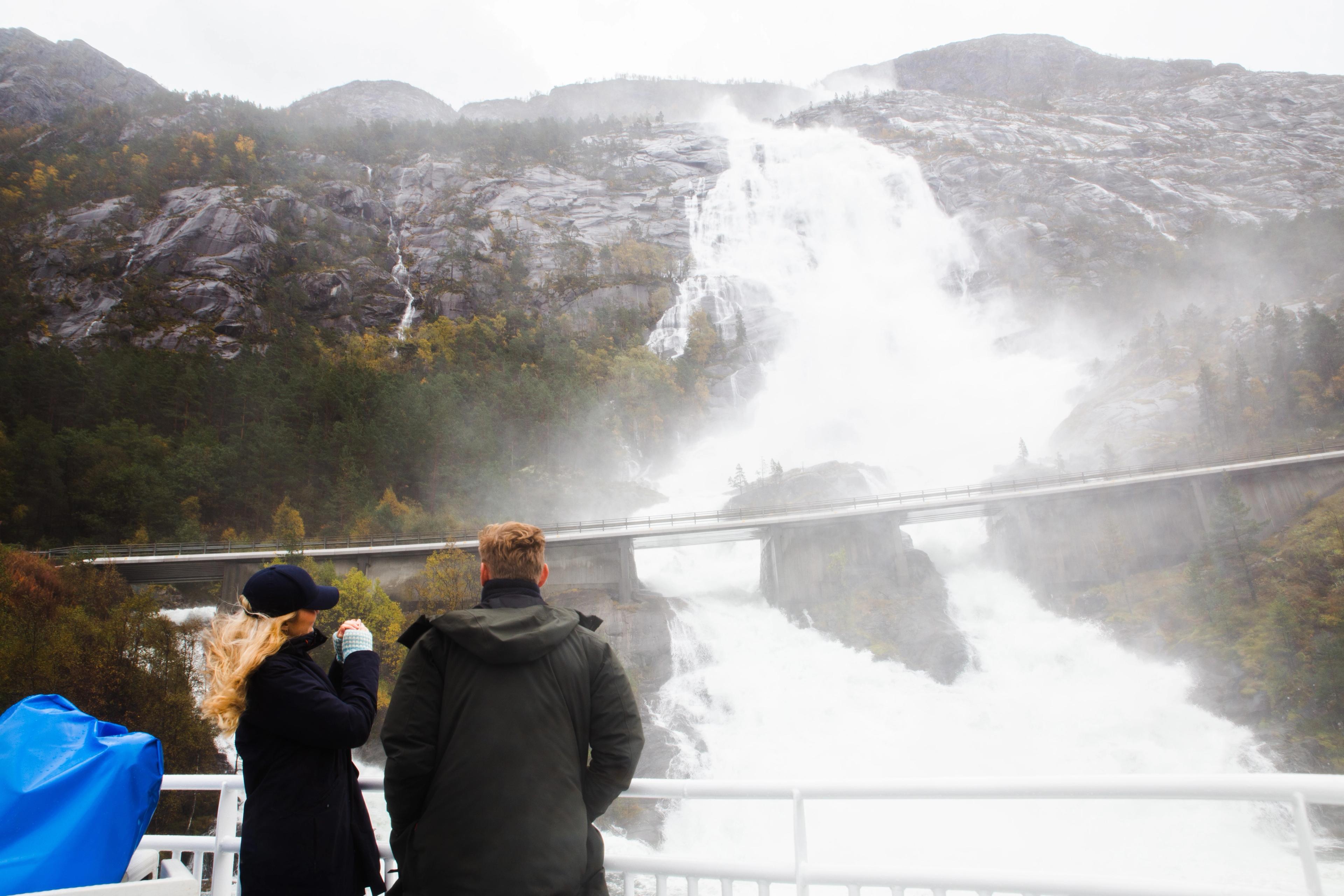 Two people enjoying the view of Langfoss in Åkrafjorden