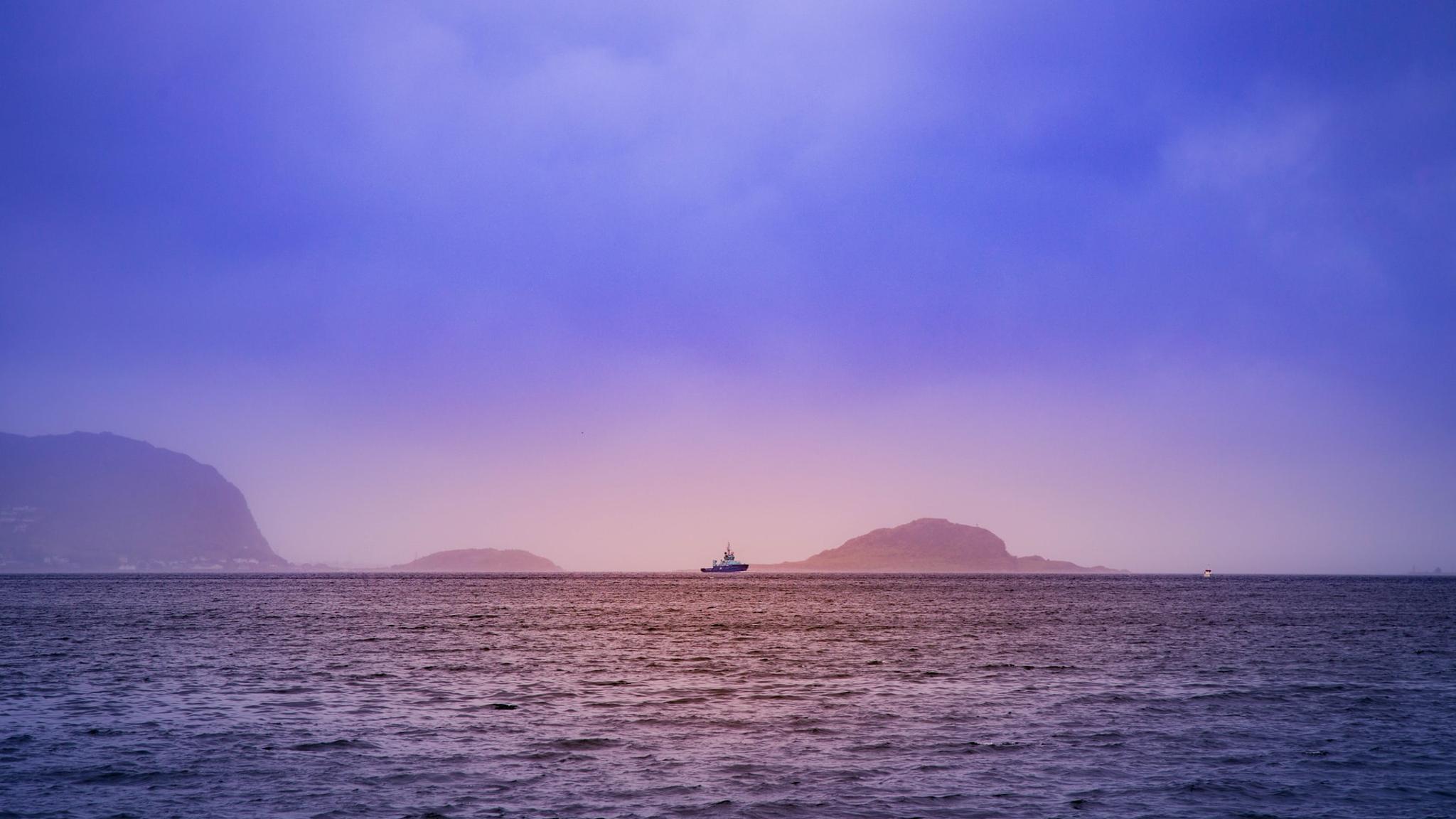 Boat in the horizon outside of Ålesund in Fjord Norway