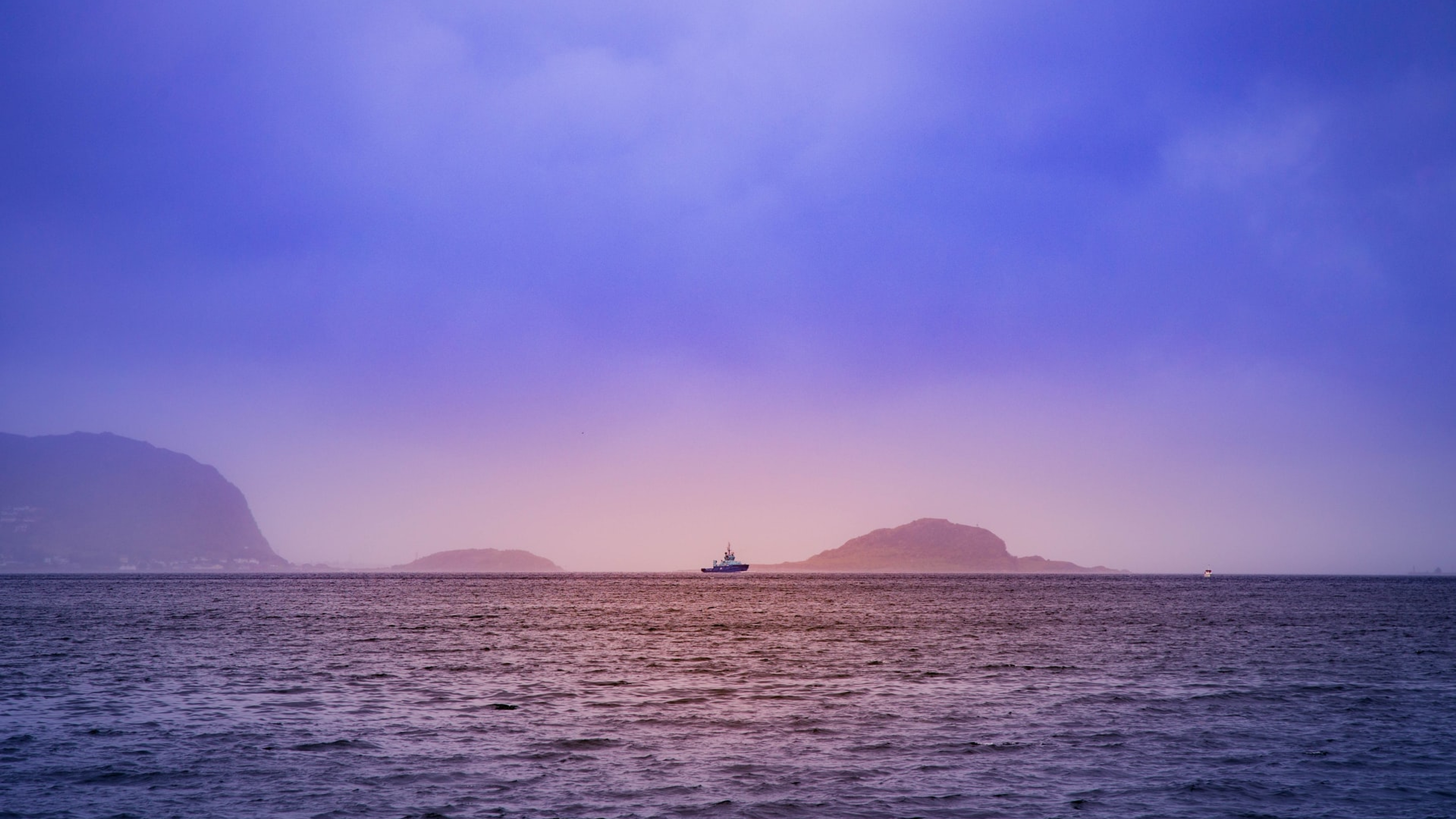 Boat in the horizon outside of Ålesund in Fjord Norway